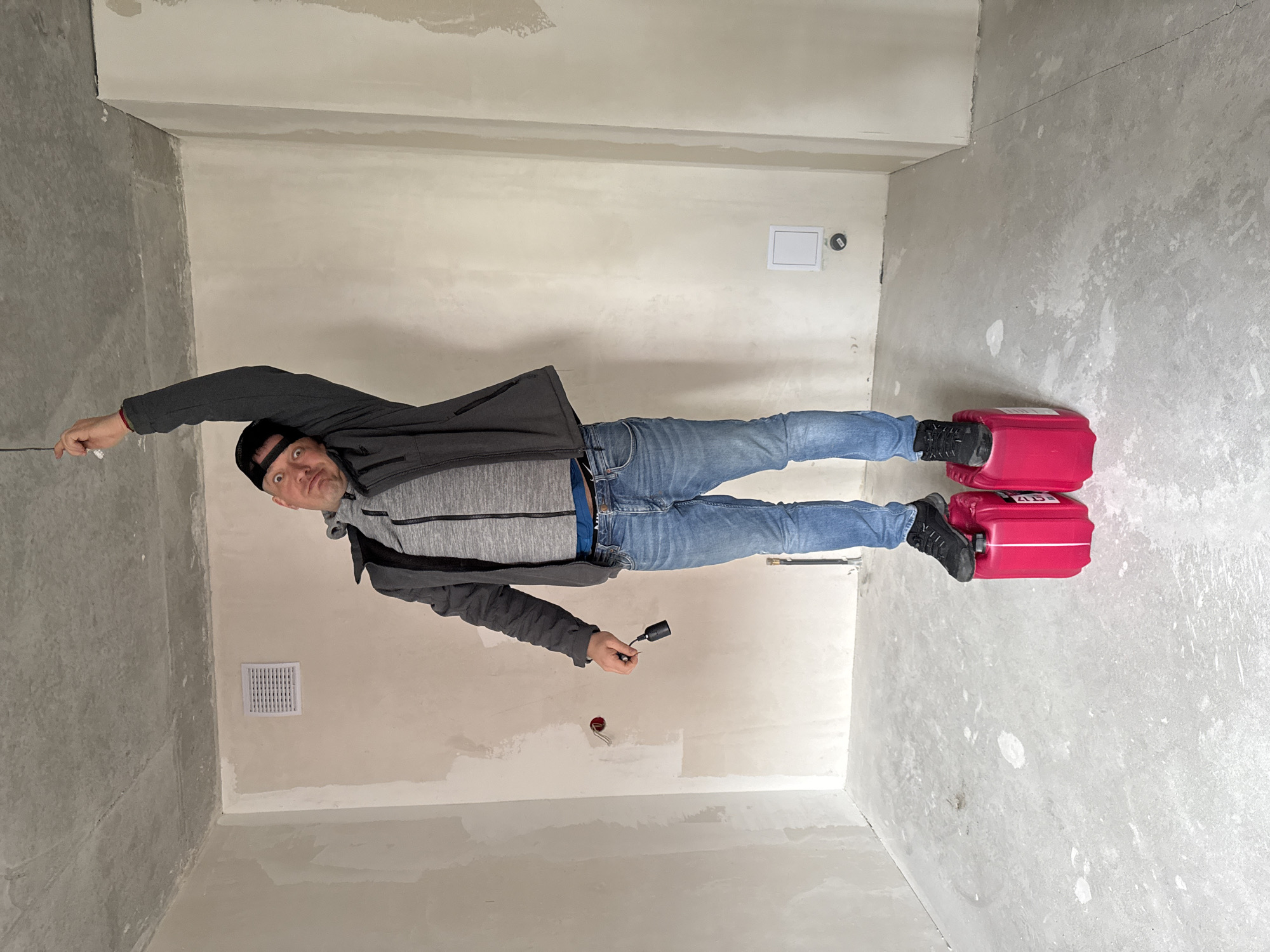 Man installs lighting fixture in unfinished room in Izhevsk
