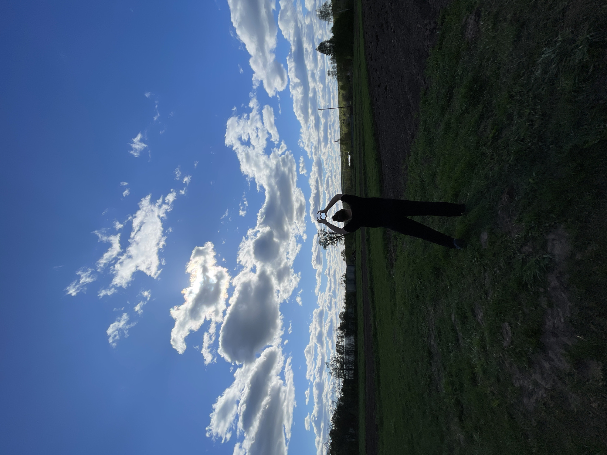 Person makes heart gestures in Russian countryside fields