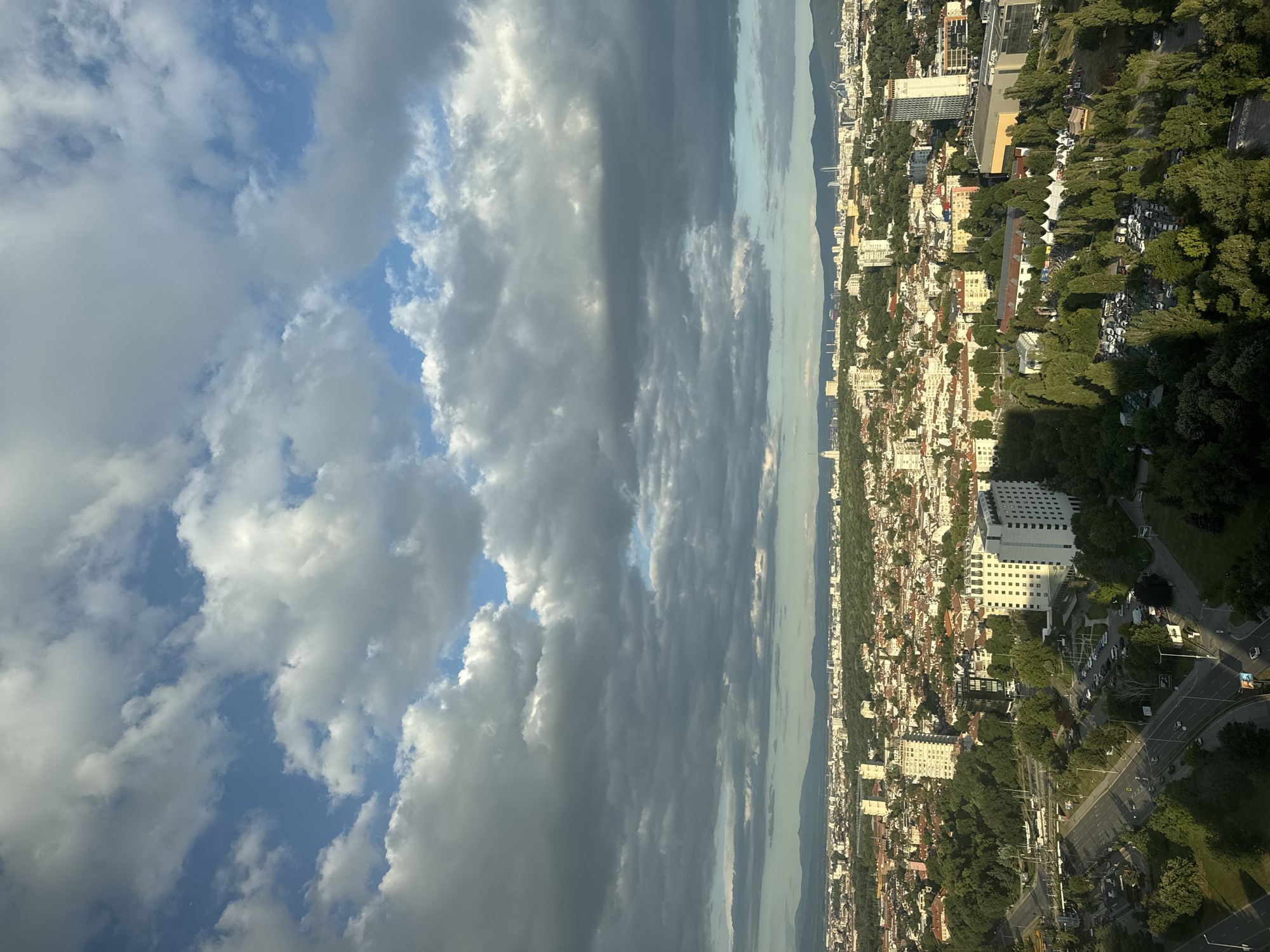 Sofia skyline from above and a high-floor lounge, mid-afternoon.