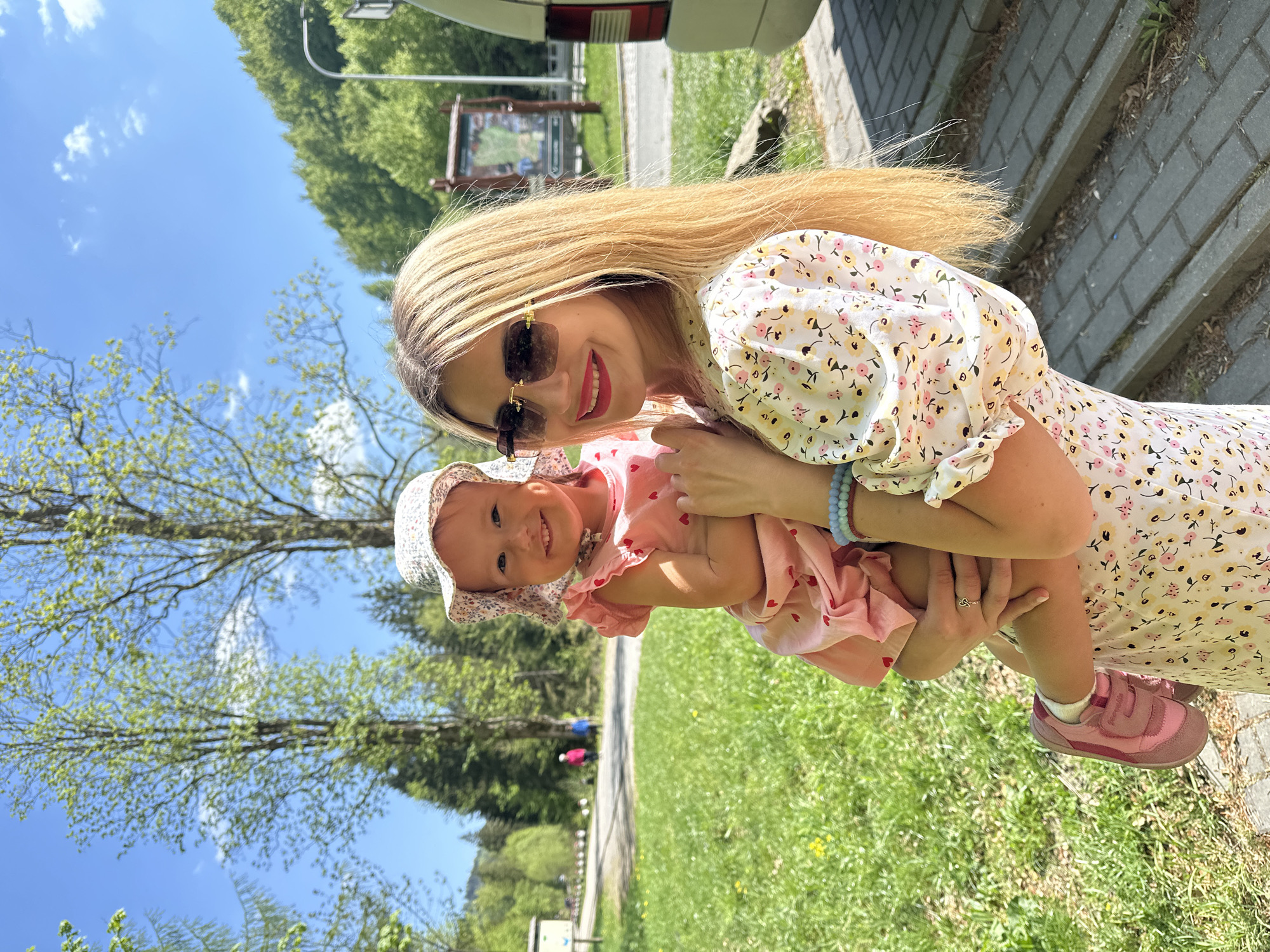 Woman with baby uses public fountain in Wisła