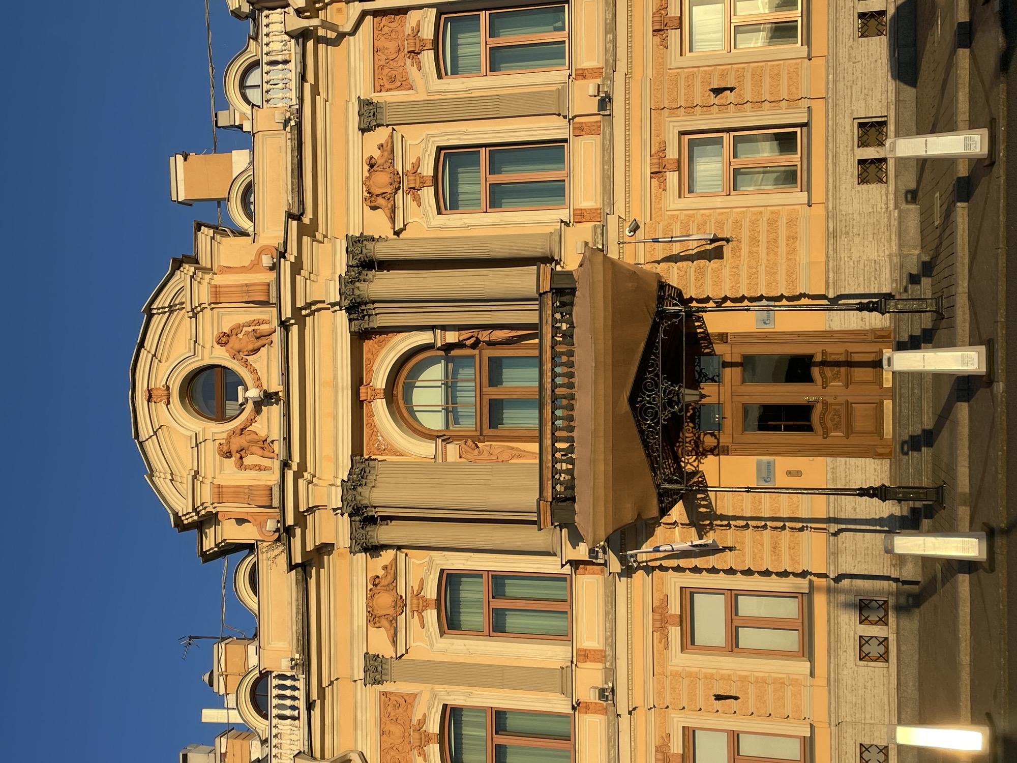 Classical building exterior and a shimmering sunset over water