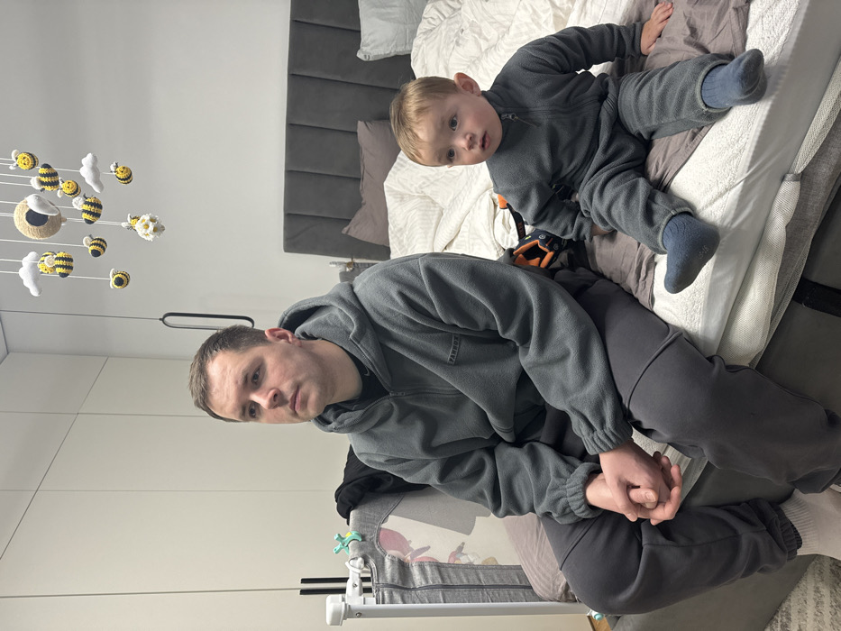 Father and child share quiet moment on bed in Odintsovo