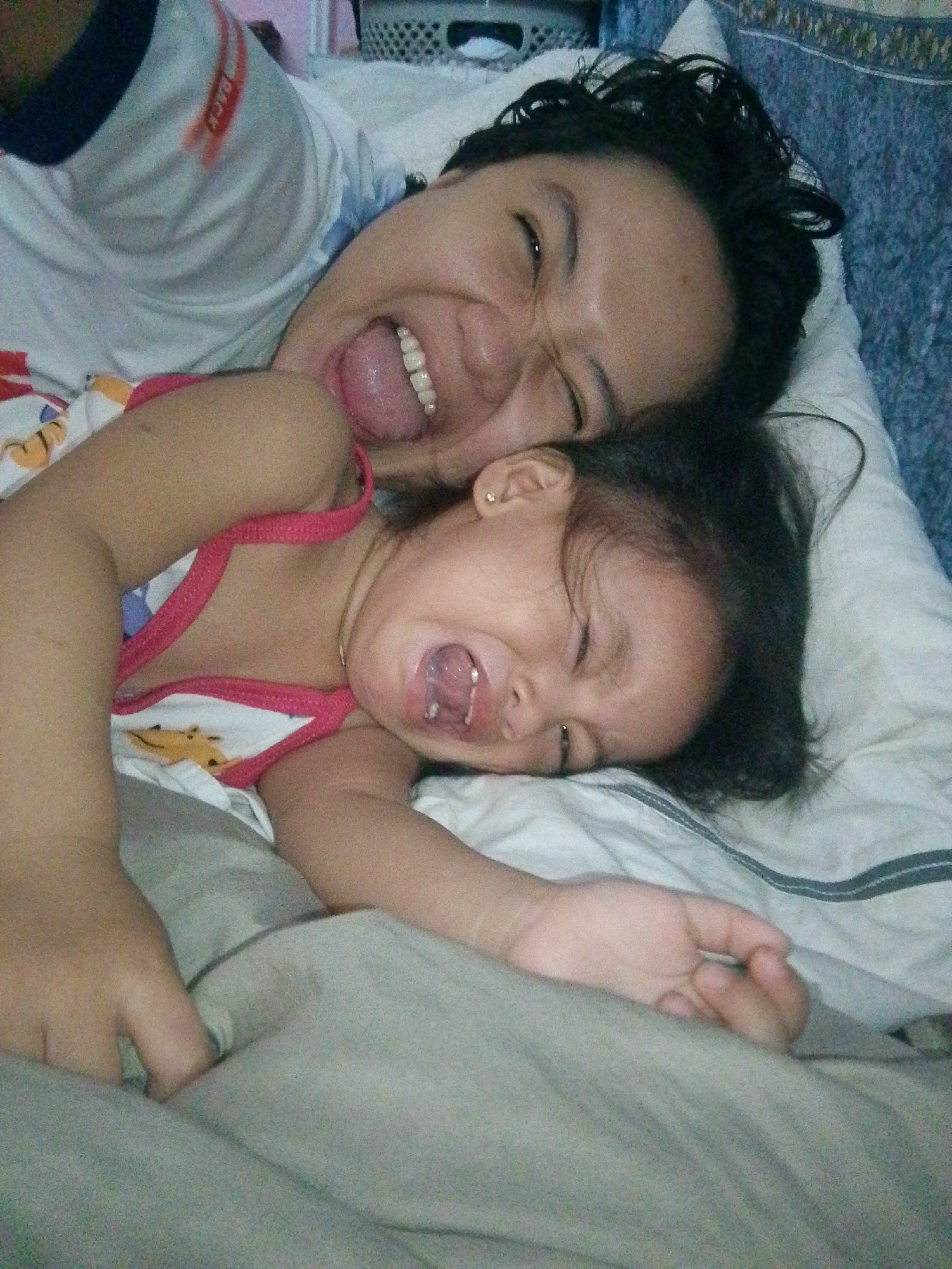 Adult and child resting together on bed in domestic setting
