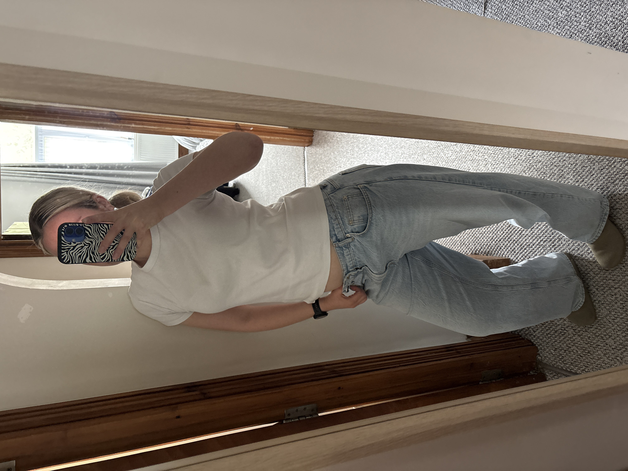 Person takes mirror selfie in Manchester wearing casual attire