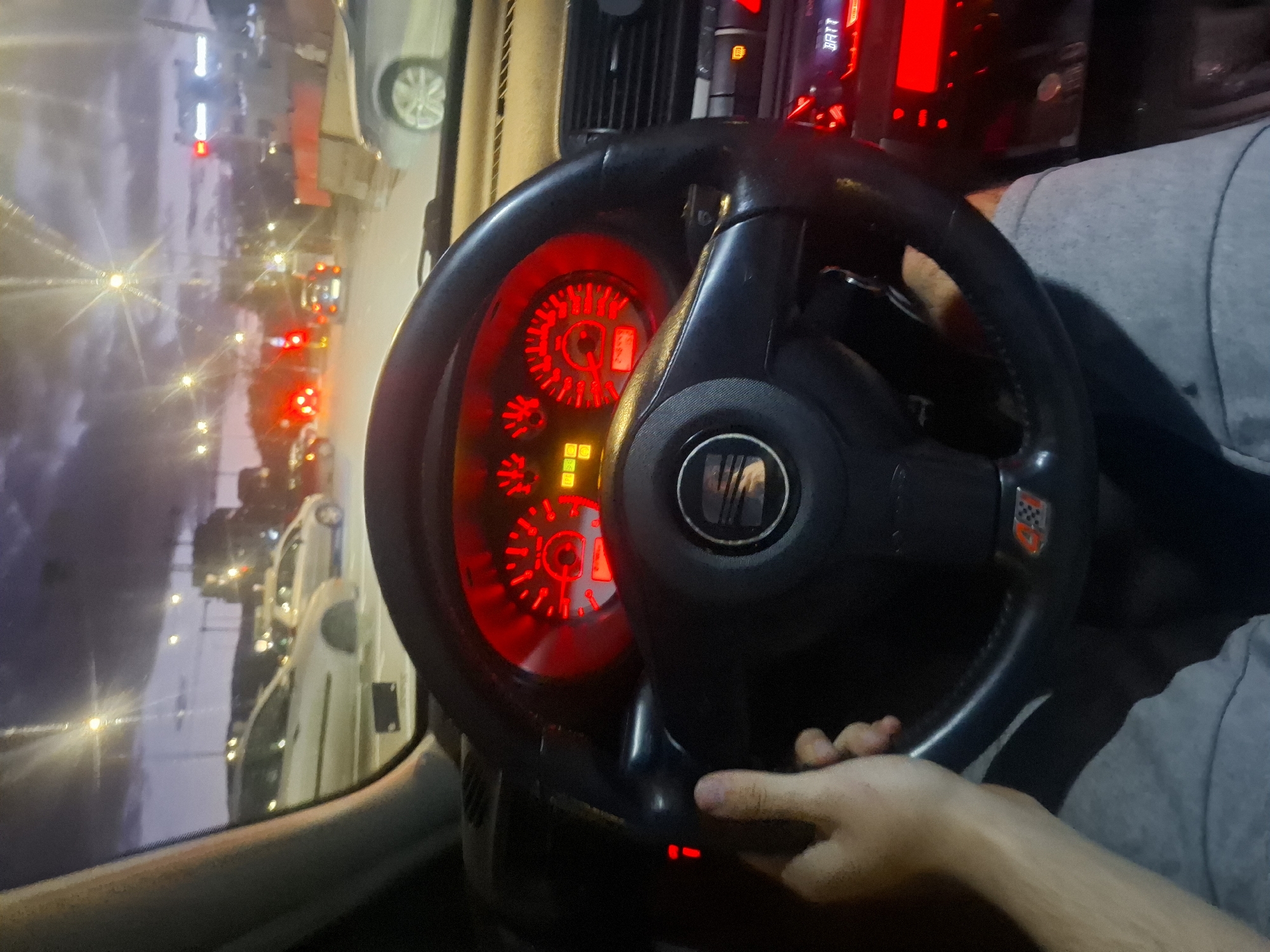 Driver photographed red-lit car interior in Sofia evening