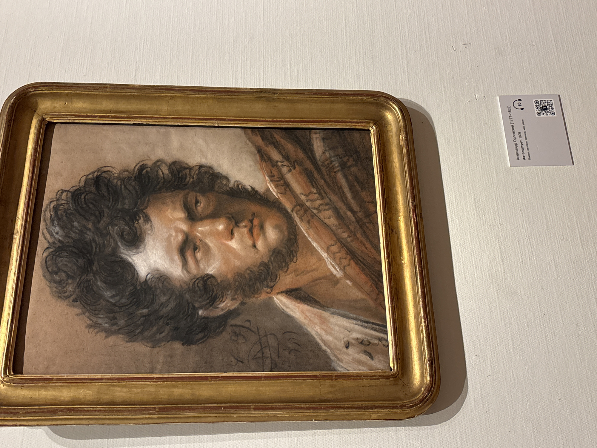 Woman photographs historical portrait collection at Moscow gallery