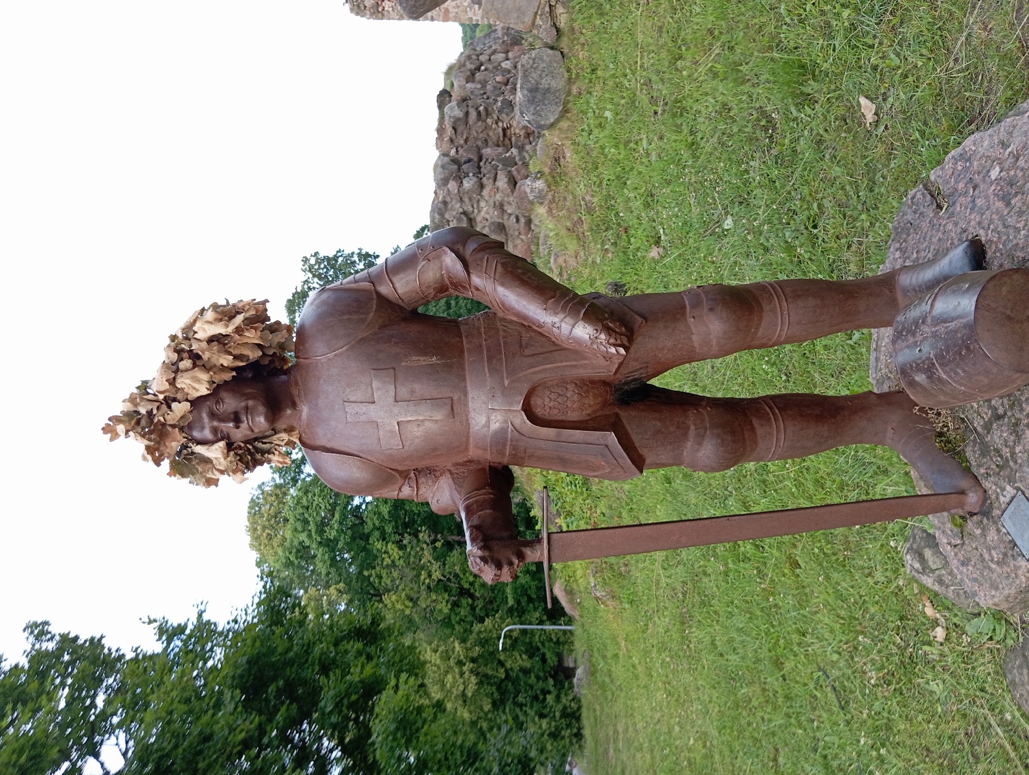 Afternoon at a ruined castle site with a lakeside outdoor event