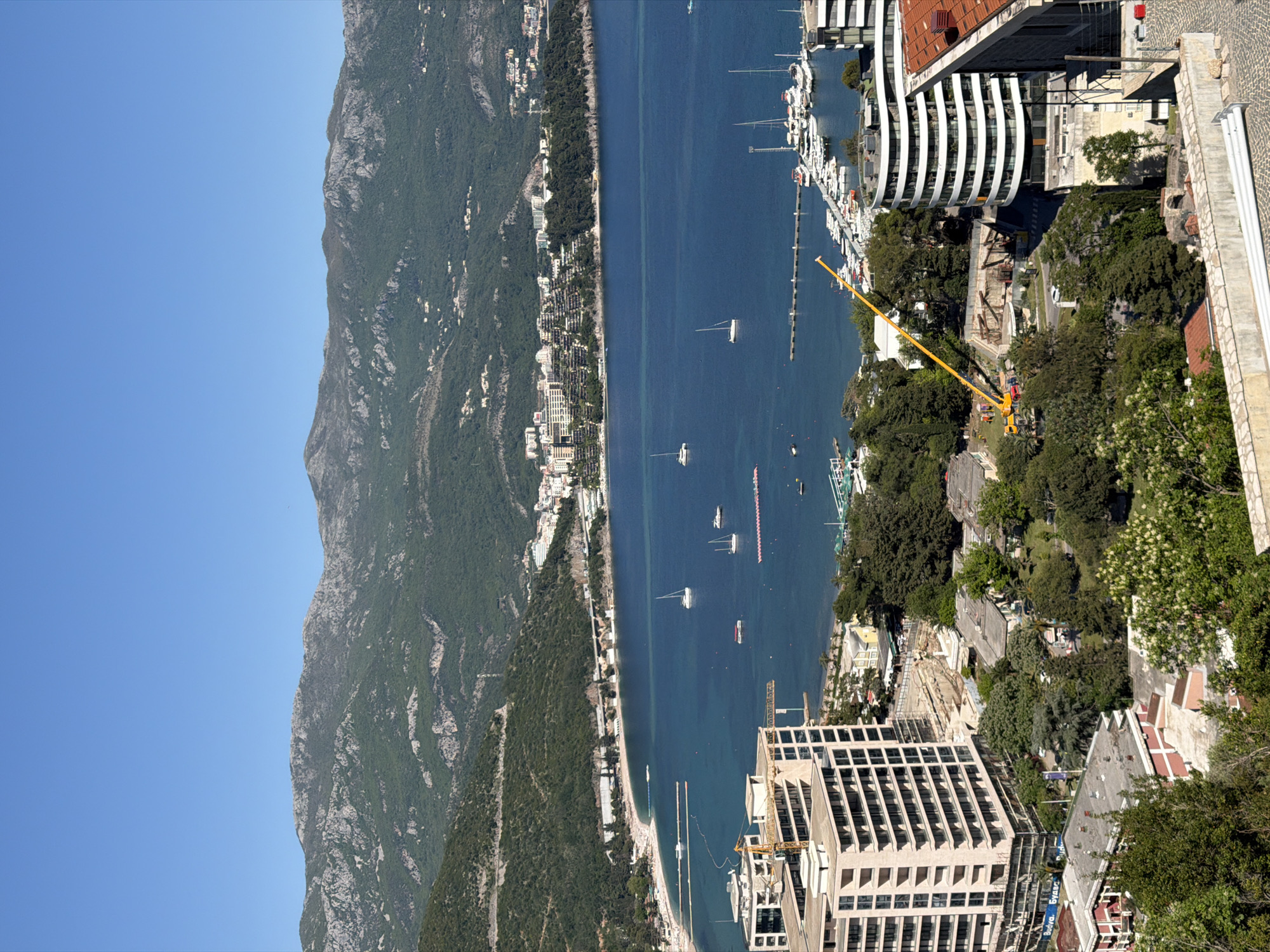 Aerial view captures Budva coastline with boats and construction activity