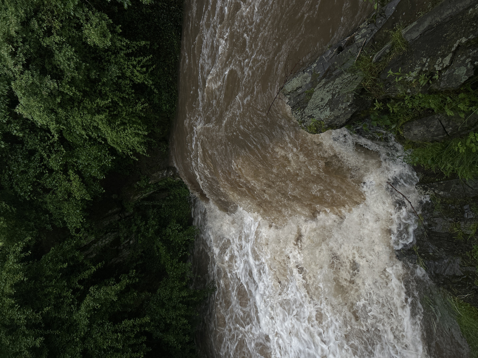 Storm-swollen waterways and flooding documented across unknown location