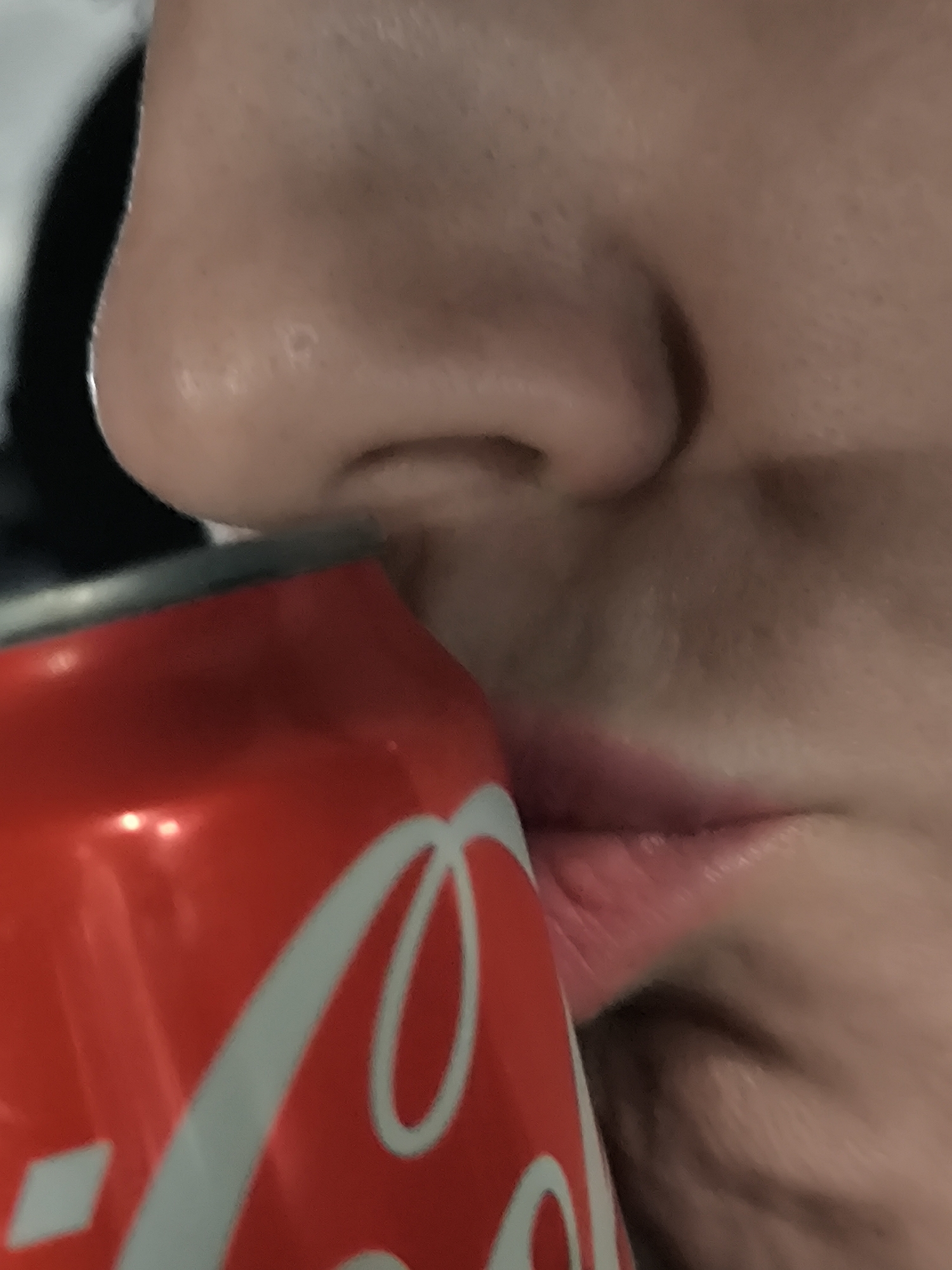 Person drinks Coca-Cola in Riga, Latvia