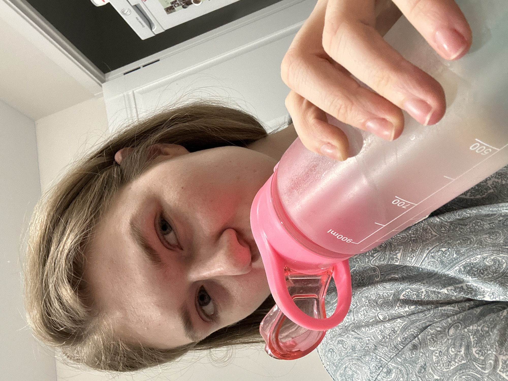 Person drinks from pink water bottle in Kazan