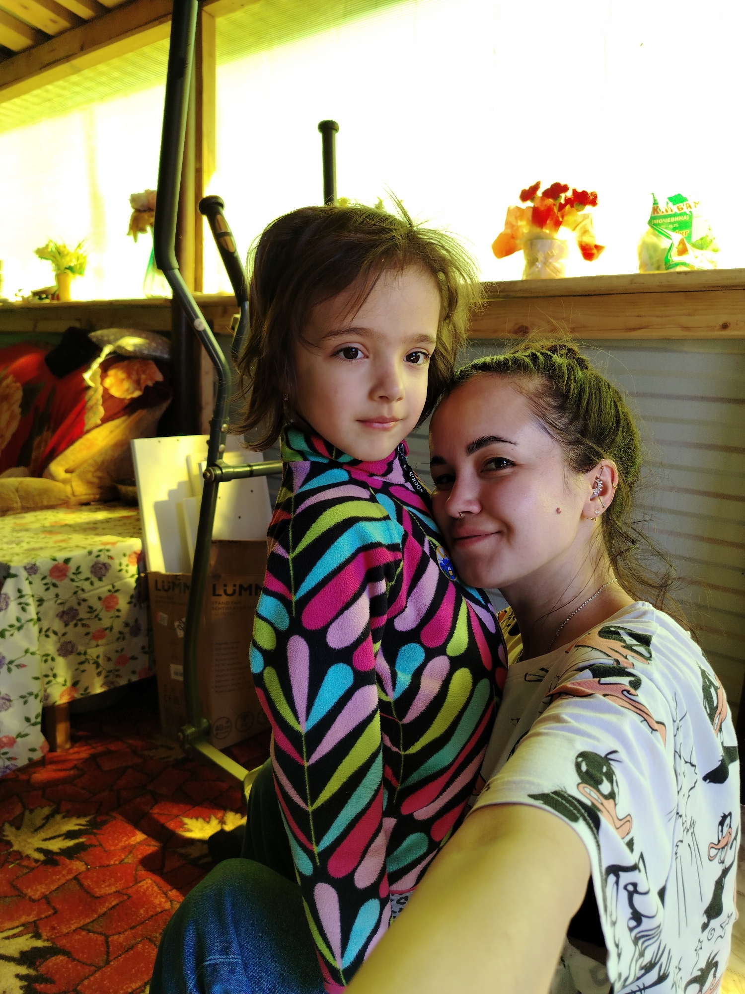 Woman photographed with child, crafts, flowers in Russian village