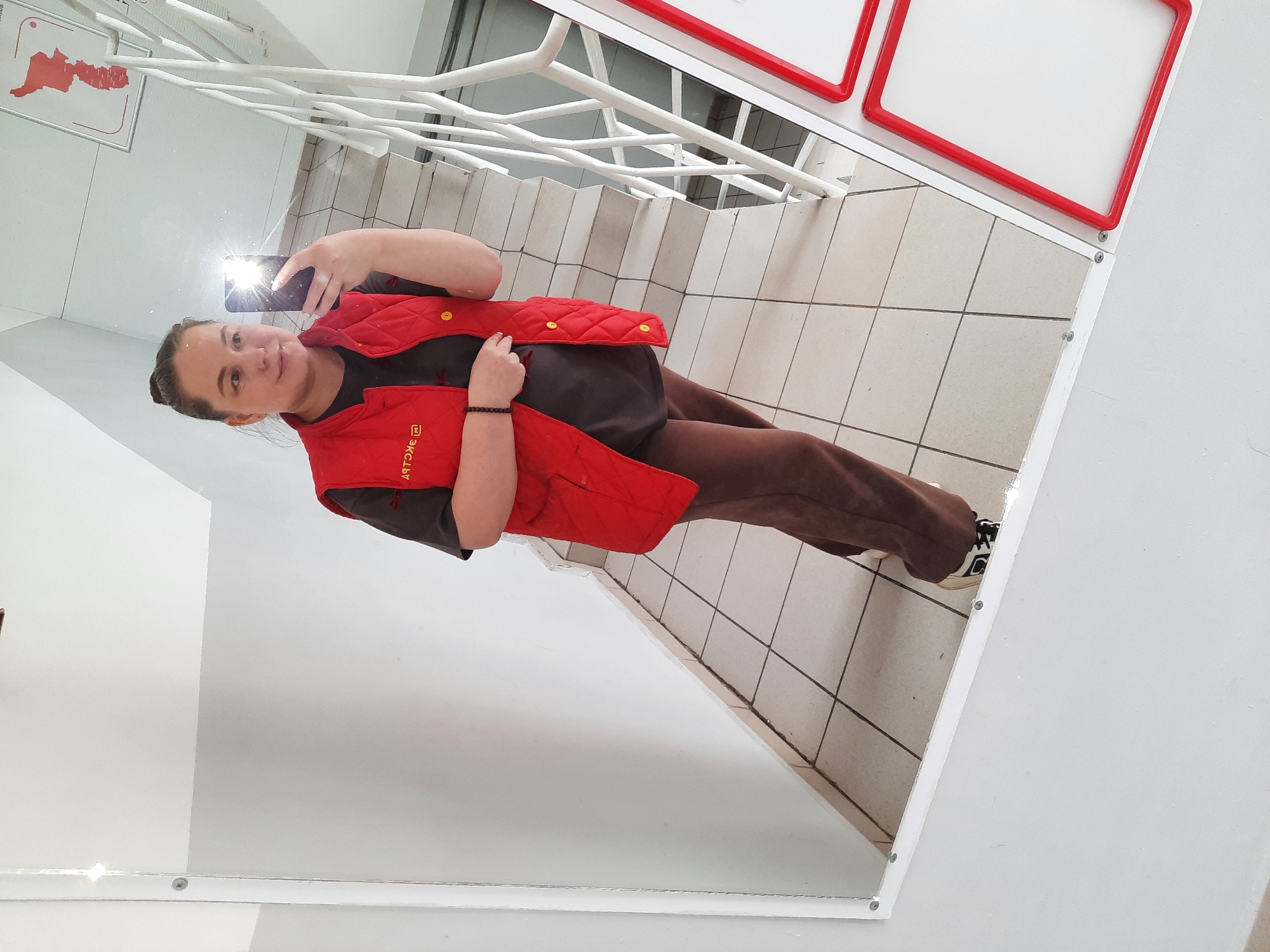 Person takes mirror selfie in Izhevsk building hallway