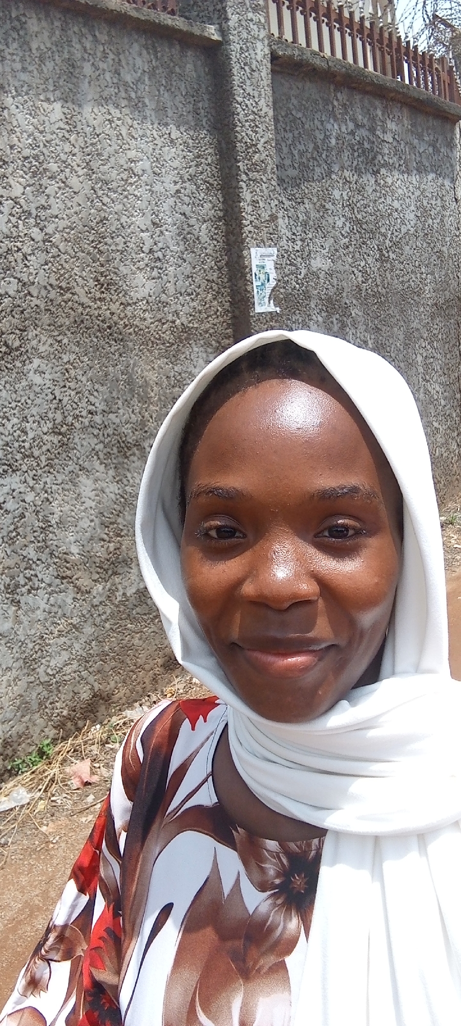 Woman in headscarf walks through Abuja neighborhood
