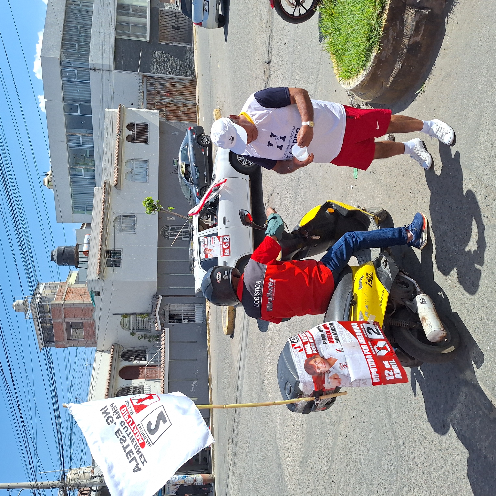 Man on scooter displays campaign materials on city street