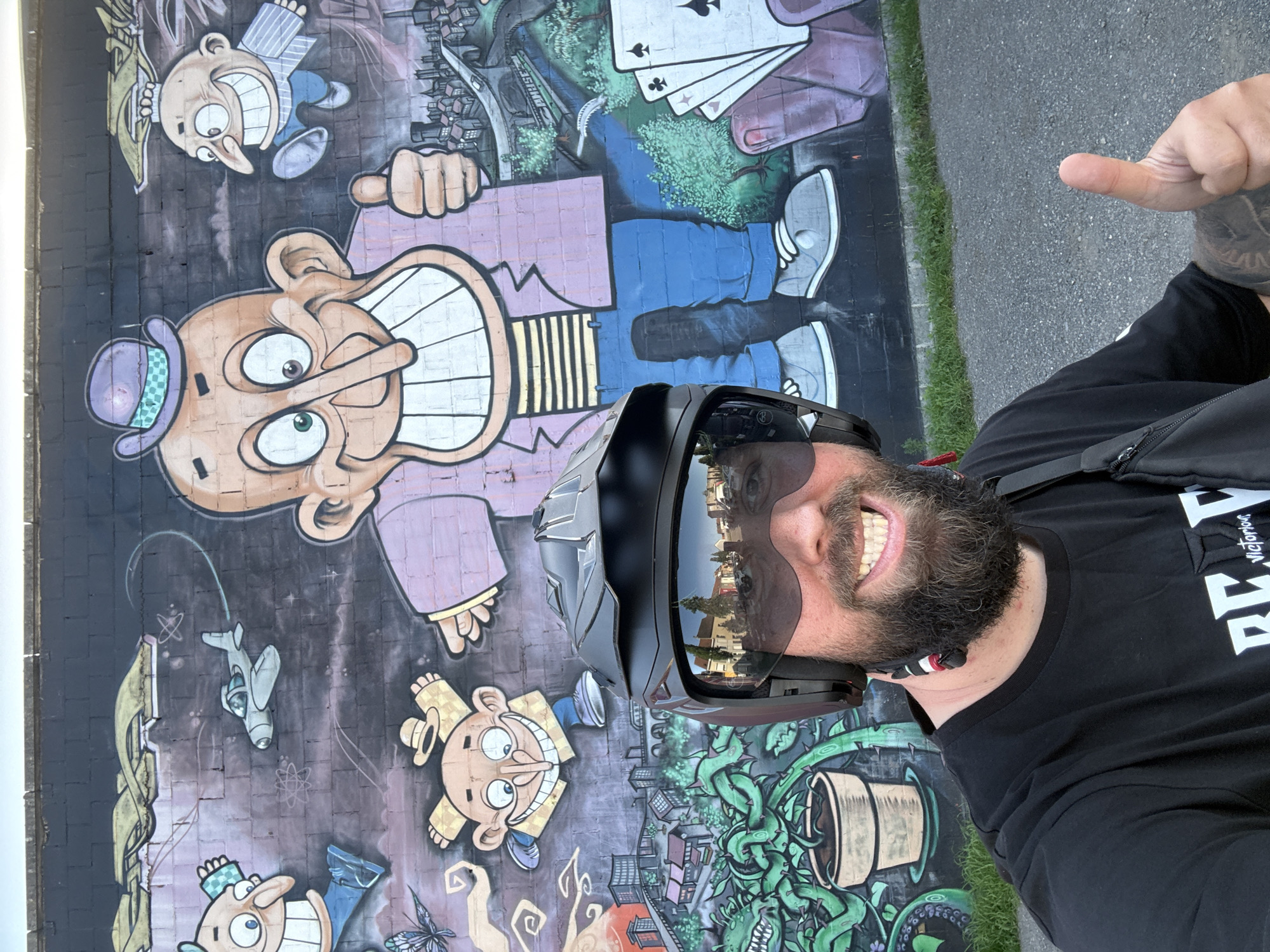 Motorcyclist poses near cartoon mural in Ghent