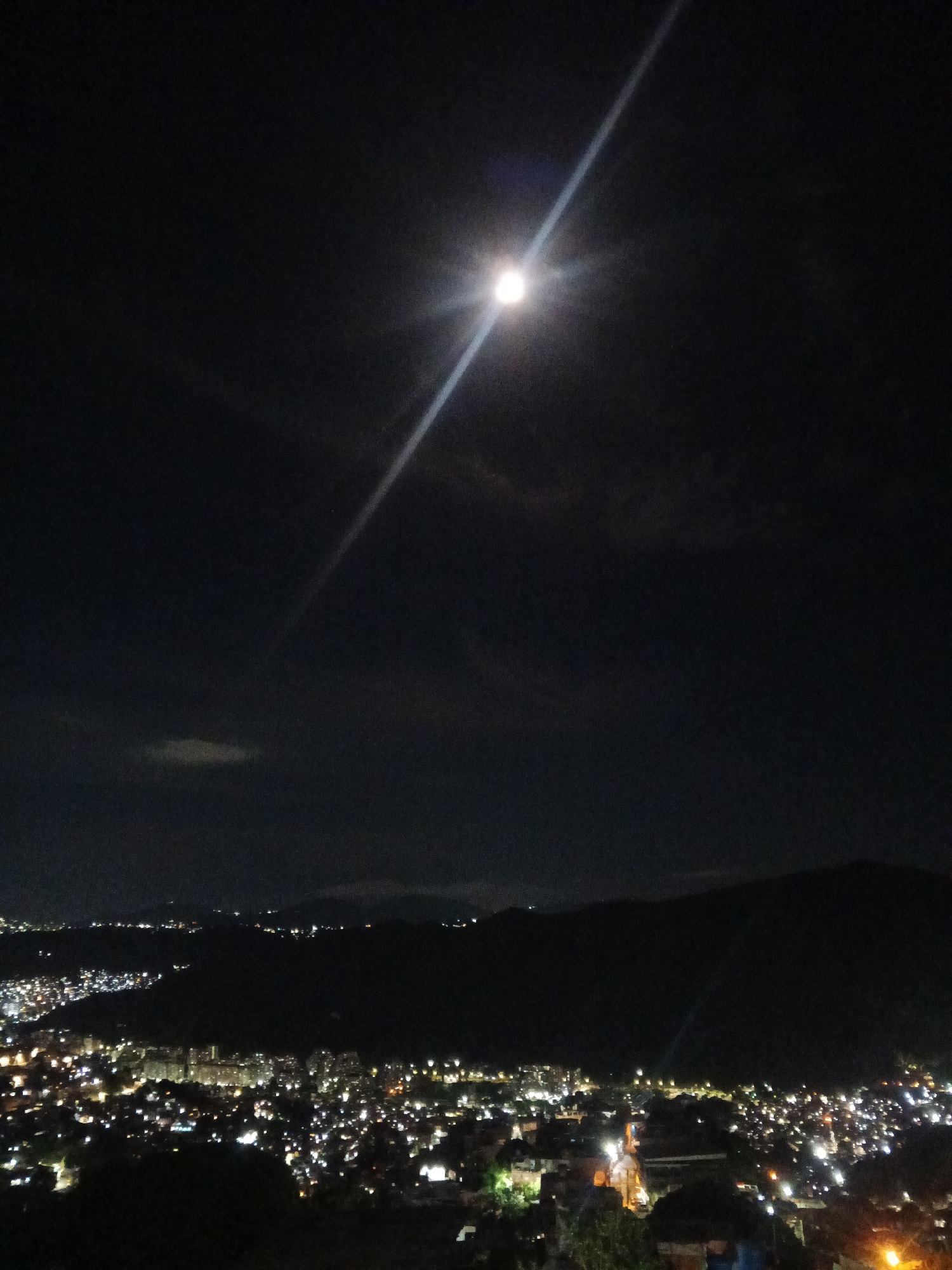 Caracas glows at night under a full moon