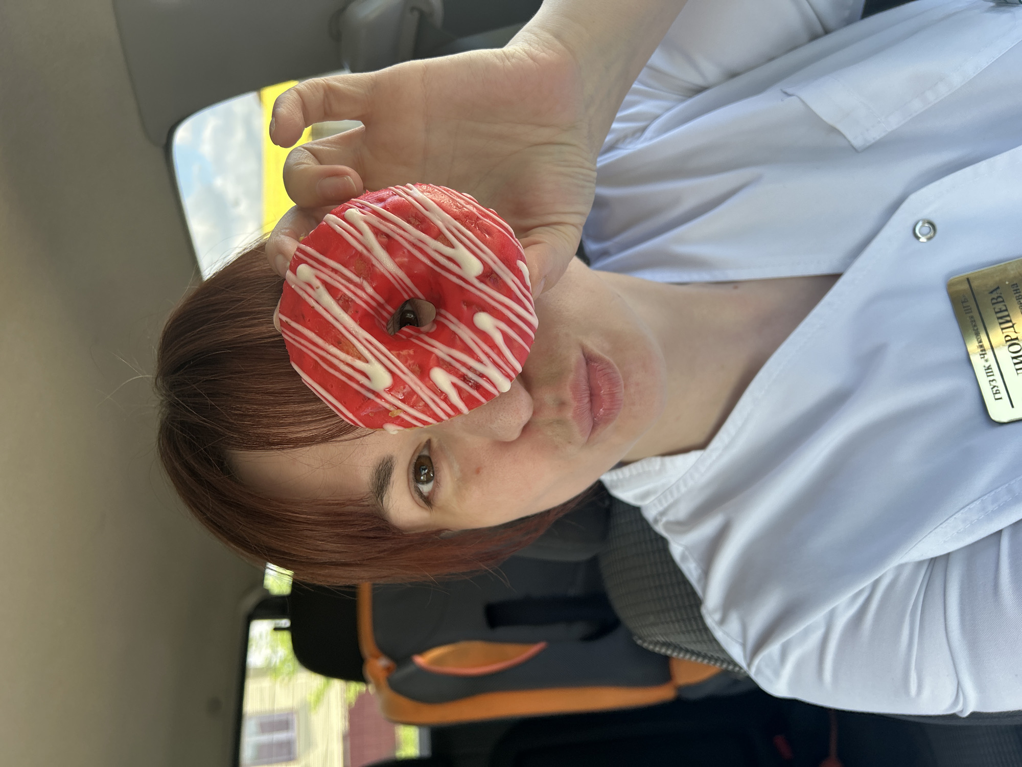 Woman poses playfully with donut, captured outdoors in Russia