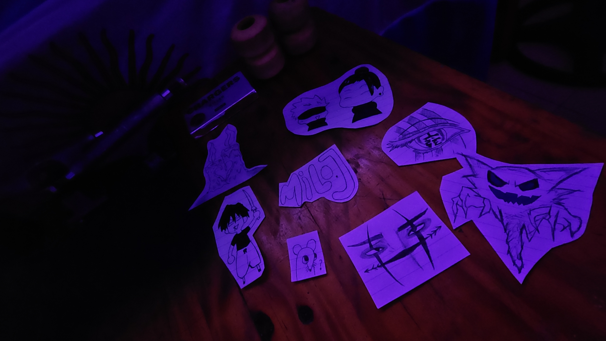 Cartoon drawings found on wooden surface under purple light