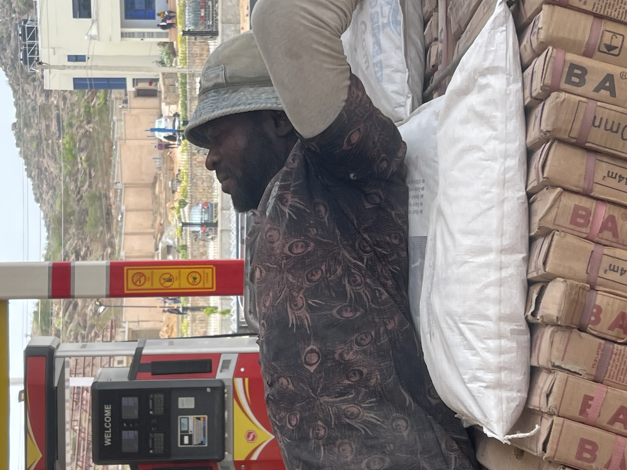 Man carries goods in commercial area, Jos Nigeria