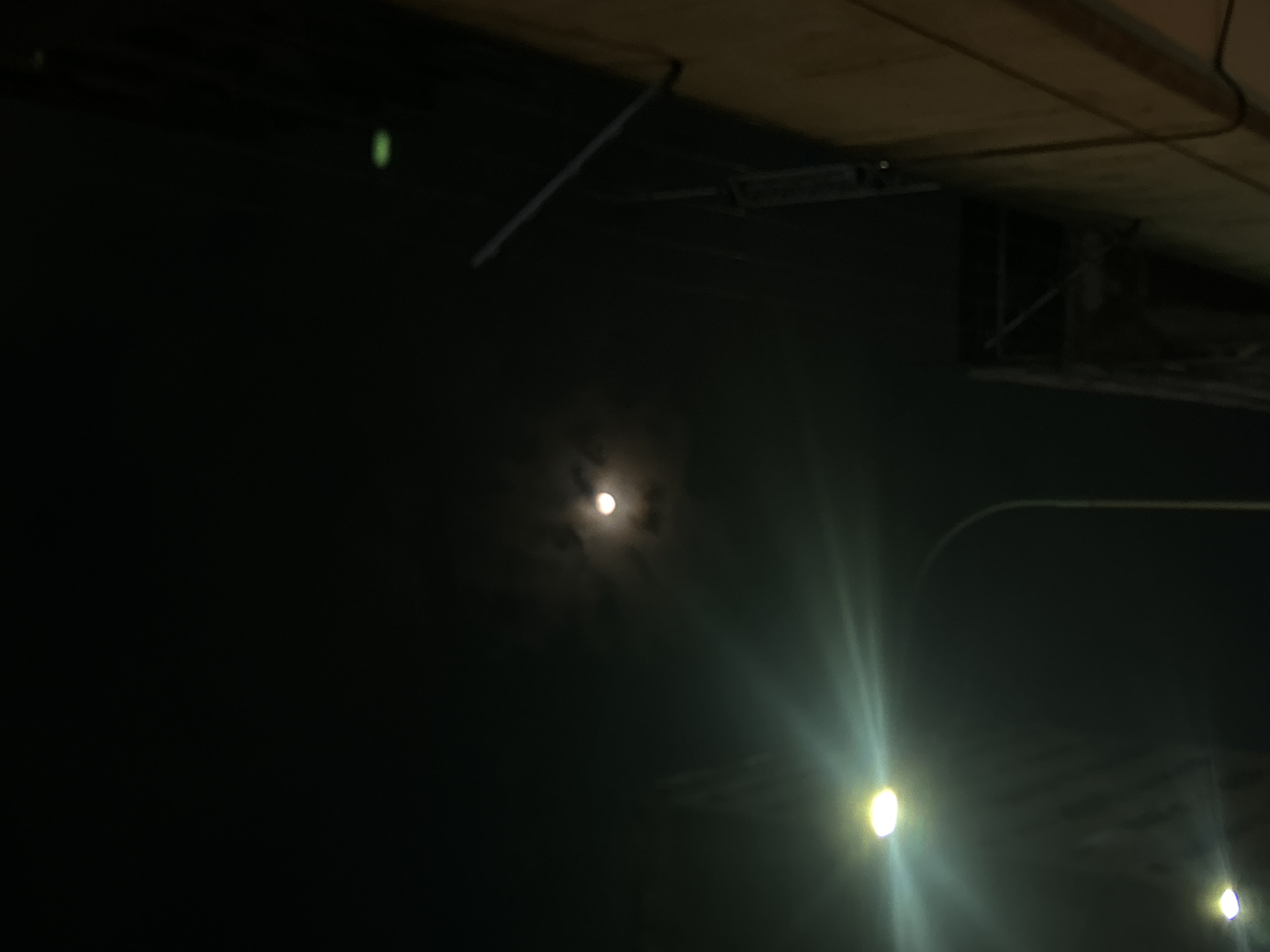 Moon visible over Caracas skyline at night