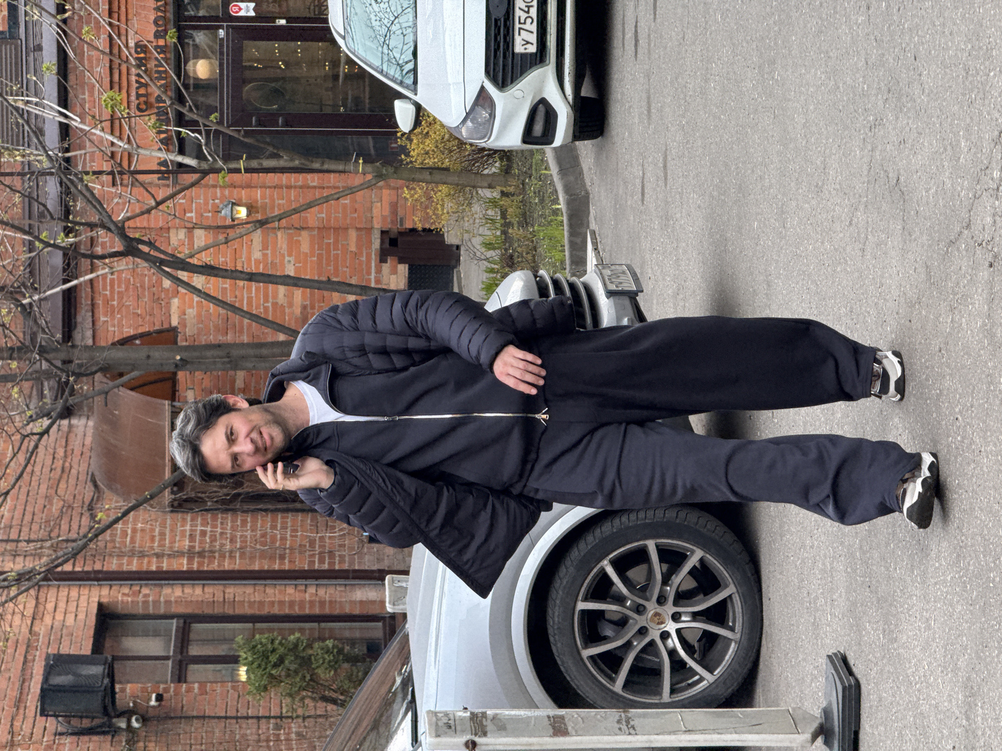 Man in tracksuit stands on Porsche hood in Moscow