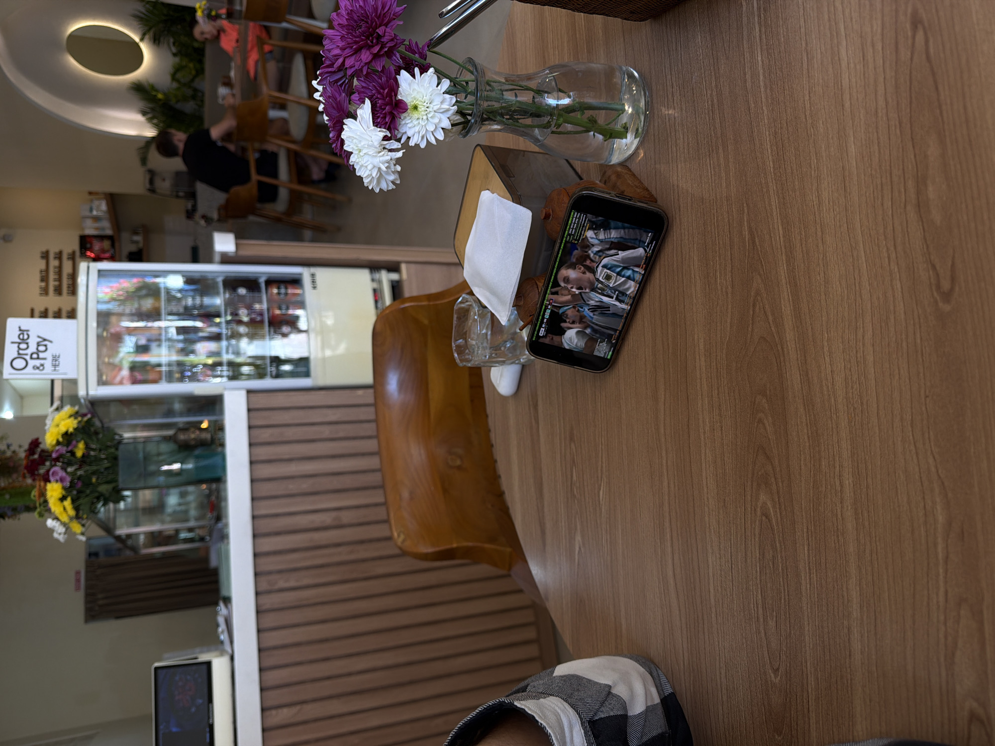 Watching a Messi soccer match on a phone at a cafe table