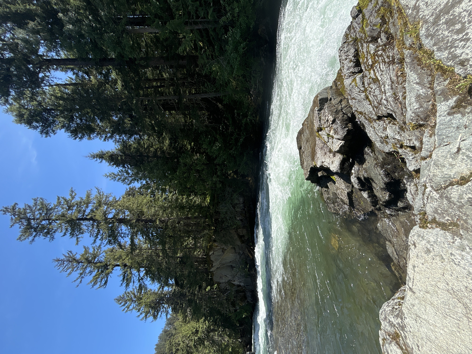 Woman sunbathes on rocky riverbank in Whistler