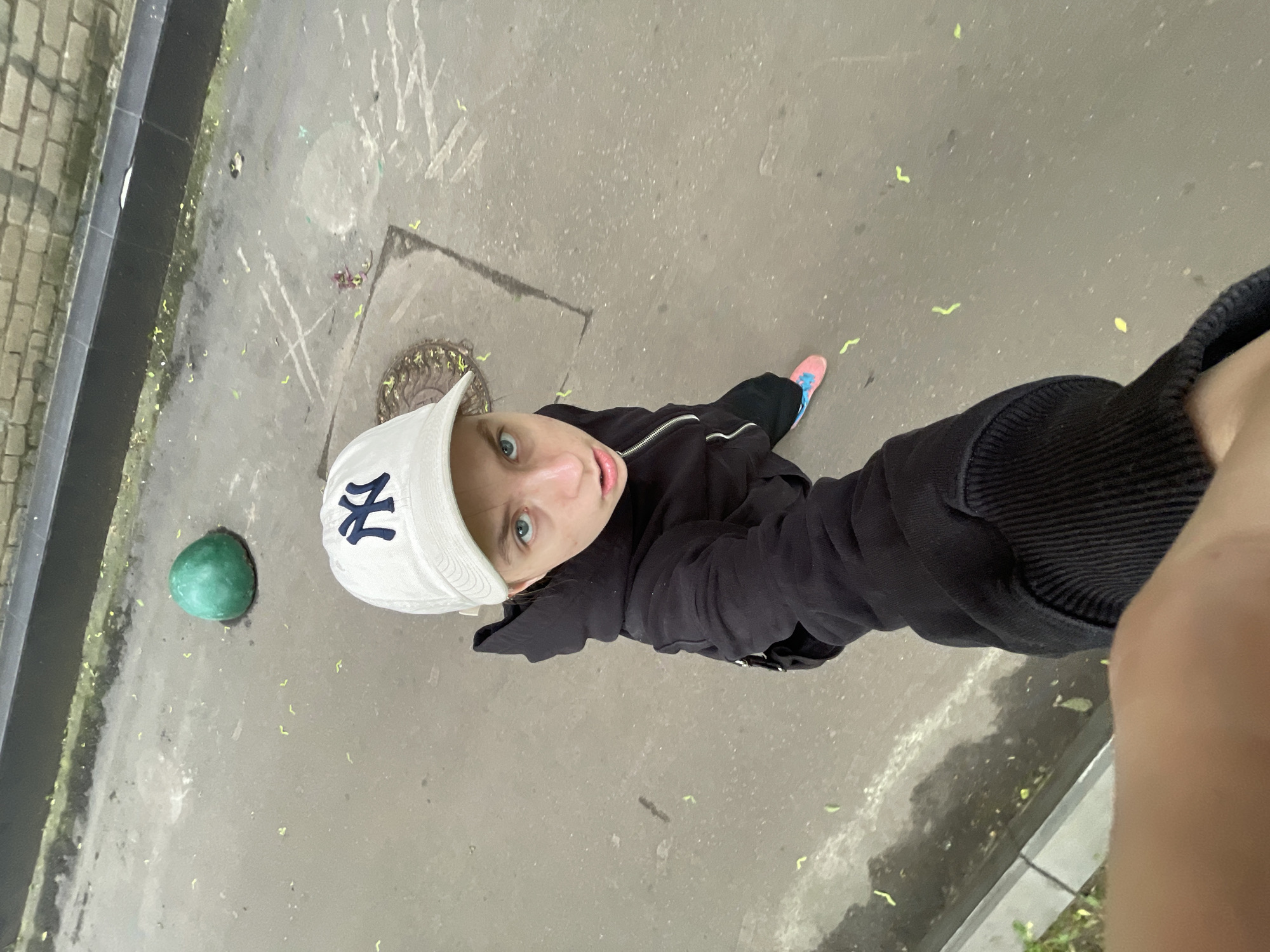 Person in NY cap photographed on Moscow street early morning