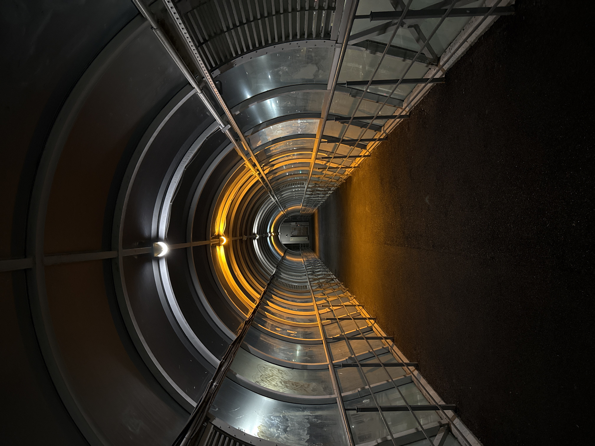 Curved glass-and-metal pedestrian tunnel in Kazan at night