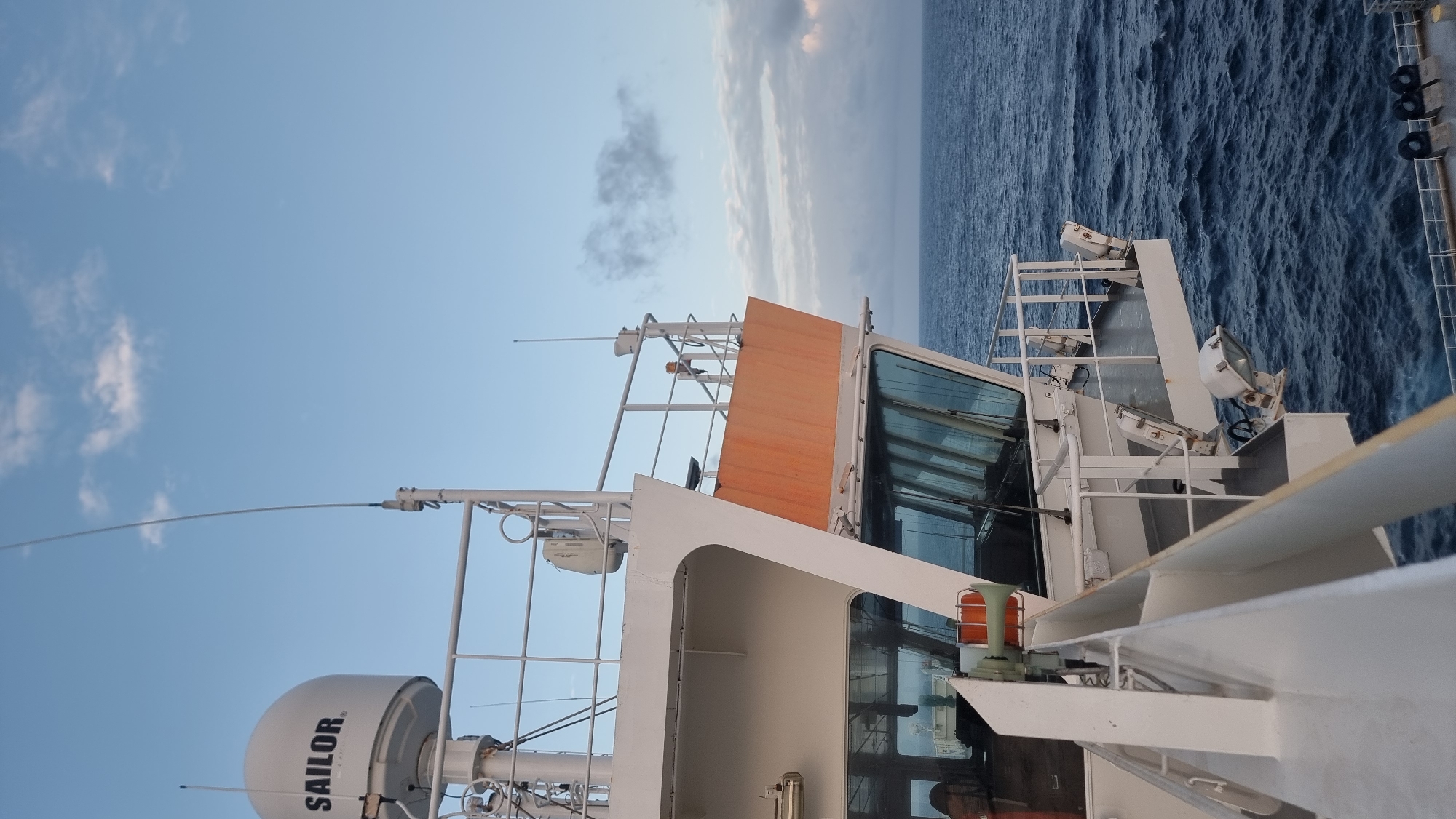 Tanker ship underway on open ocean, deck and bridge in view