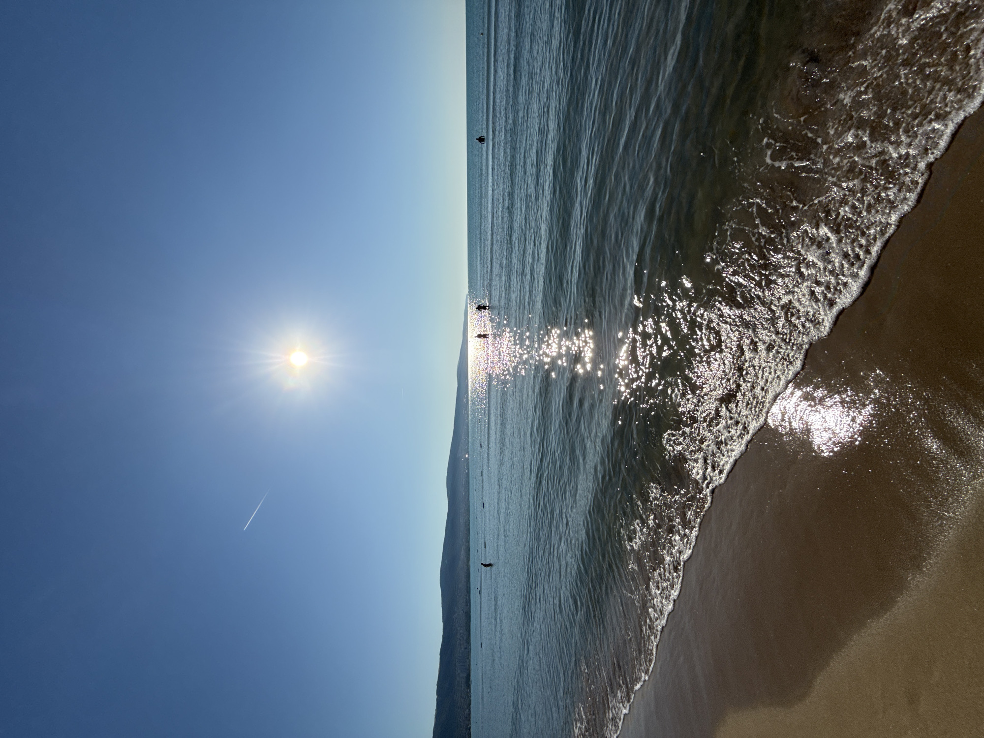 Woman takes selfies on sunny Nesebar beach morning