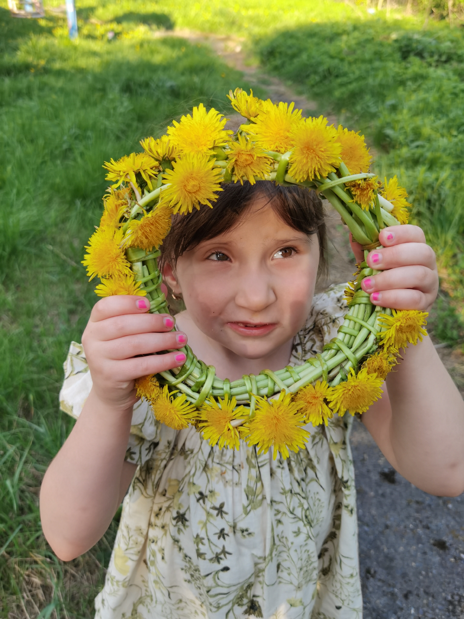Mother and daughter make dandelion crowns in Perm park