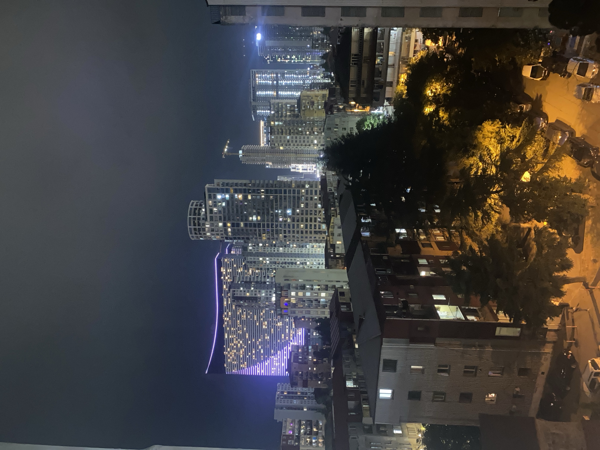 City district at night, lit towers and street activity