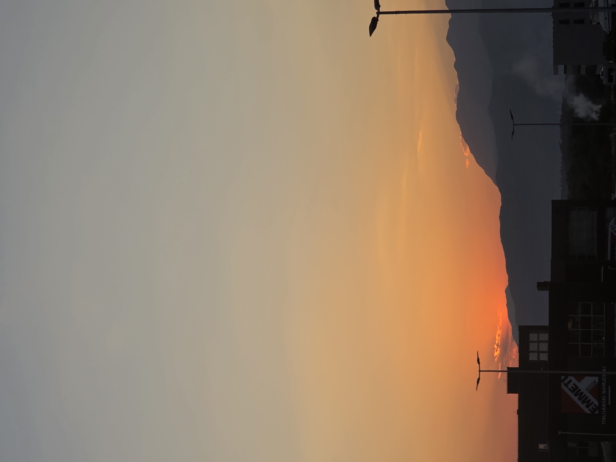 Sunset silhouettes mountains and industry over Sutvara
