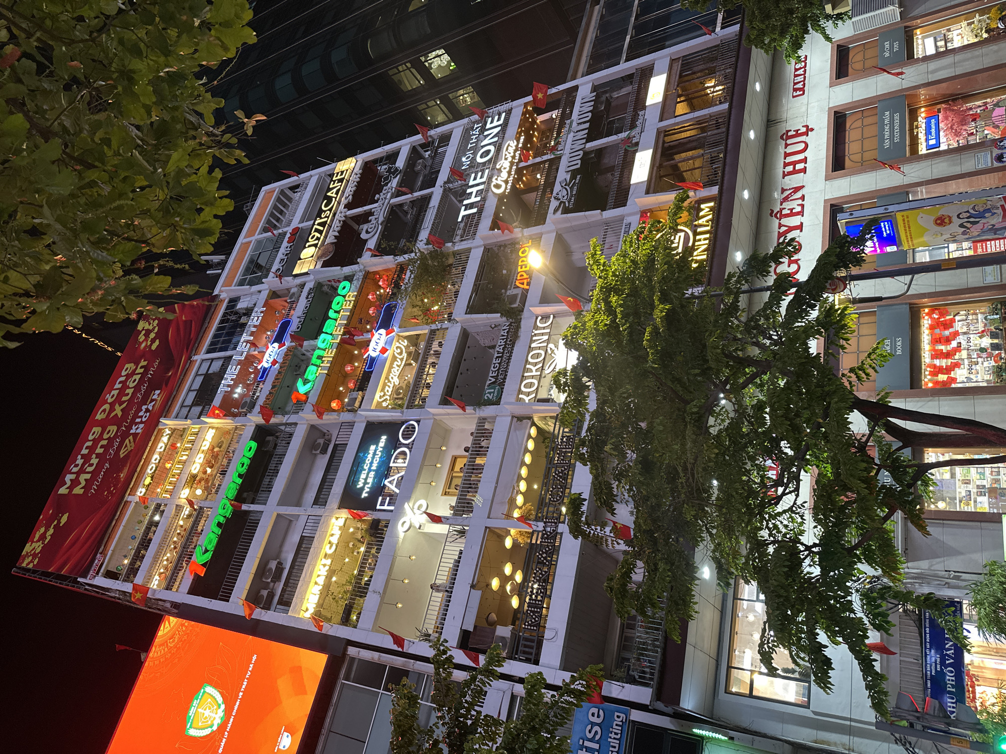 Commercial building with lit business signs observed in Thủ Đức