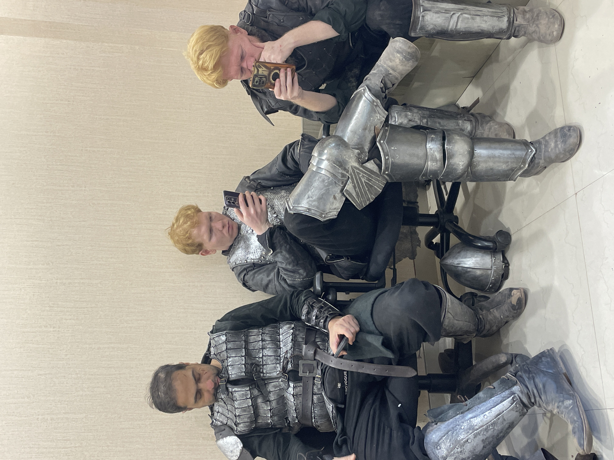 Three armored individuals seated indoors in Mumbai