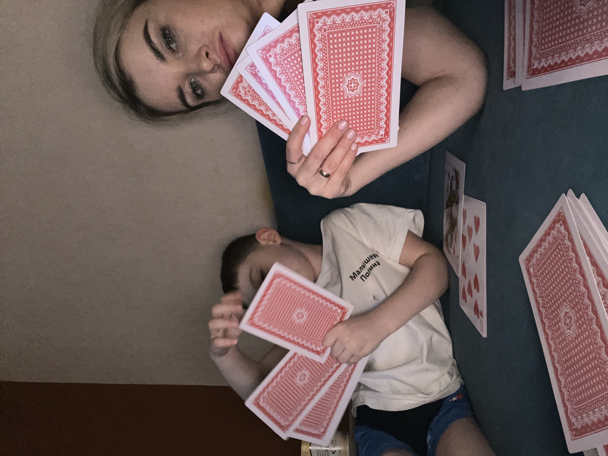 Woman and boy play cards indoors in Chaikovsky, Russia