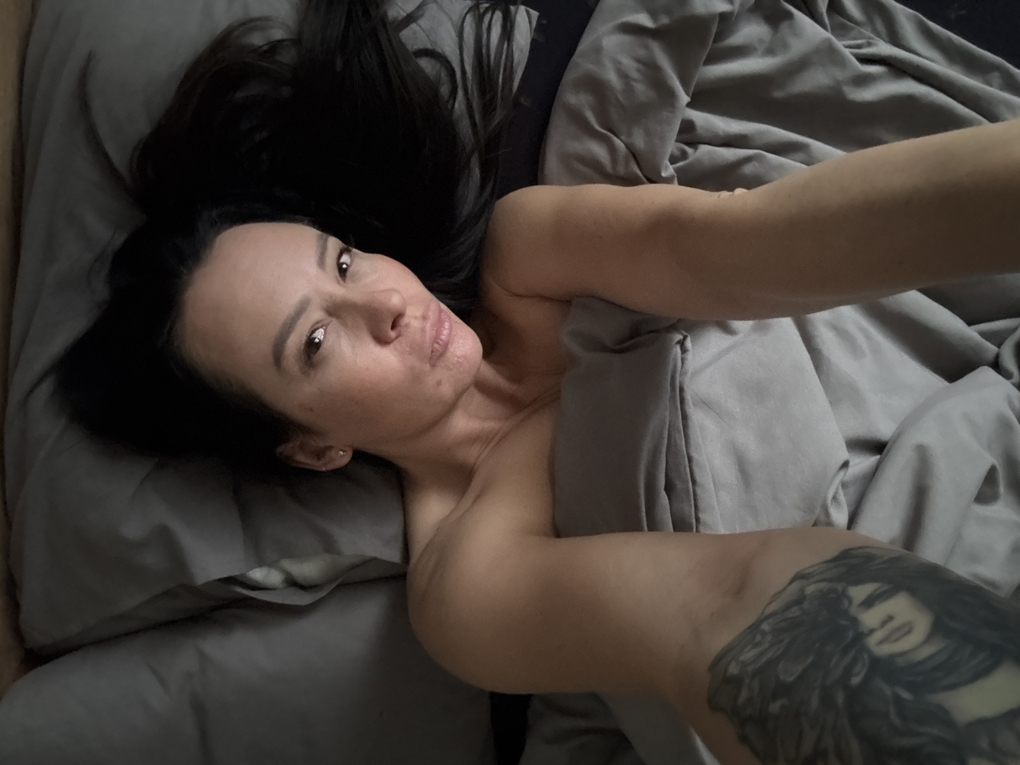 Woman rests in bed with dog in Chaikovsky
