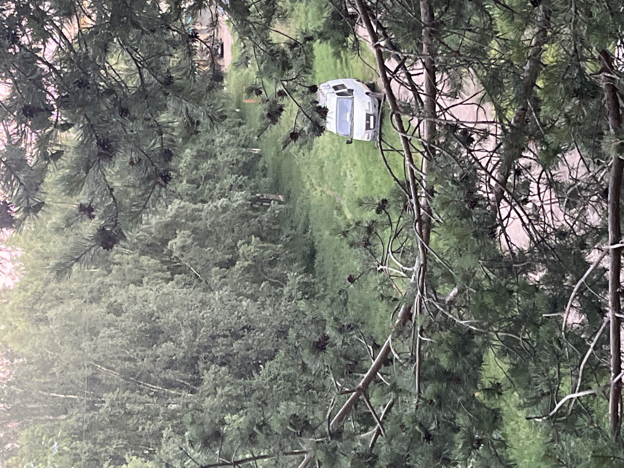 Elevated surveillance of vans parked on a rural dirt path at dusk