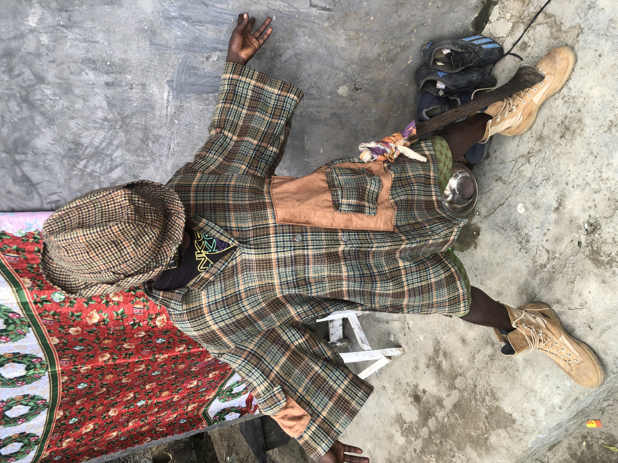 Plaid-clad figure poses against concrete in Ado, Nigeria