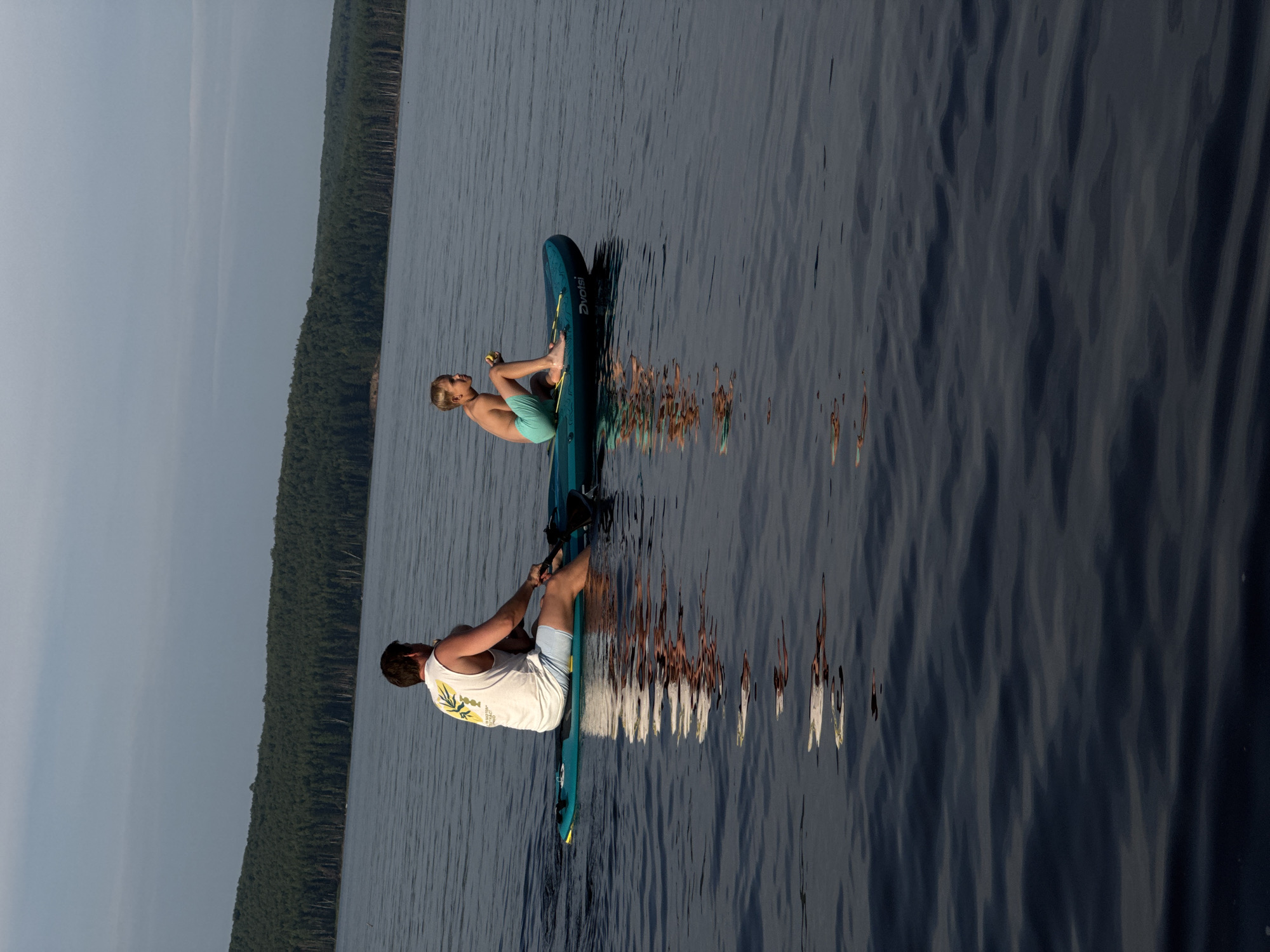 Summer afternoon paddleboarding and swimming on a calm Russian lake