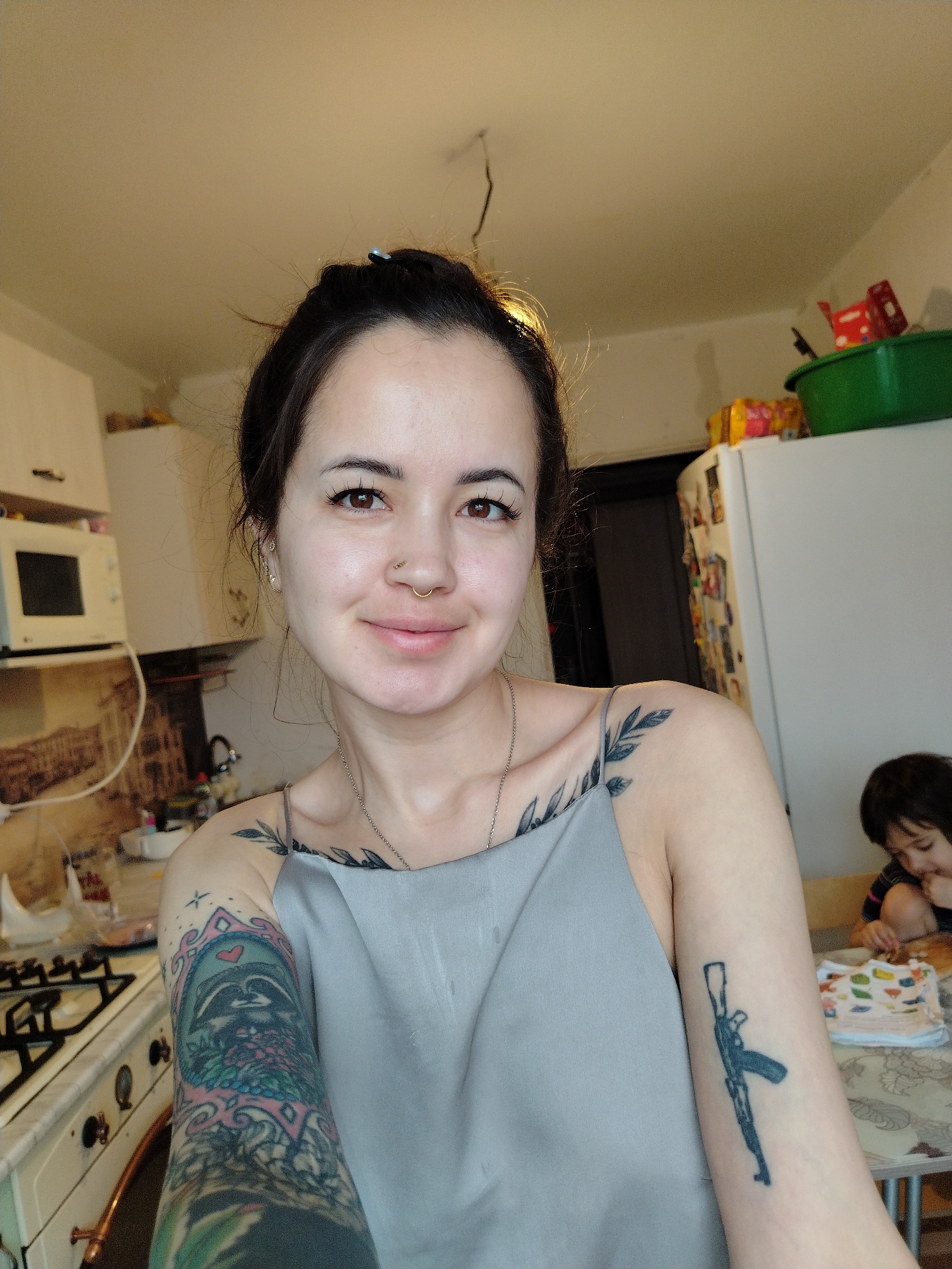 Woman takes kitchen selfie with child present in Noviy