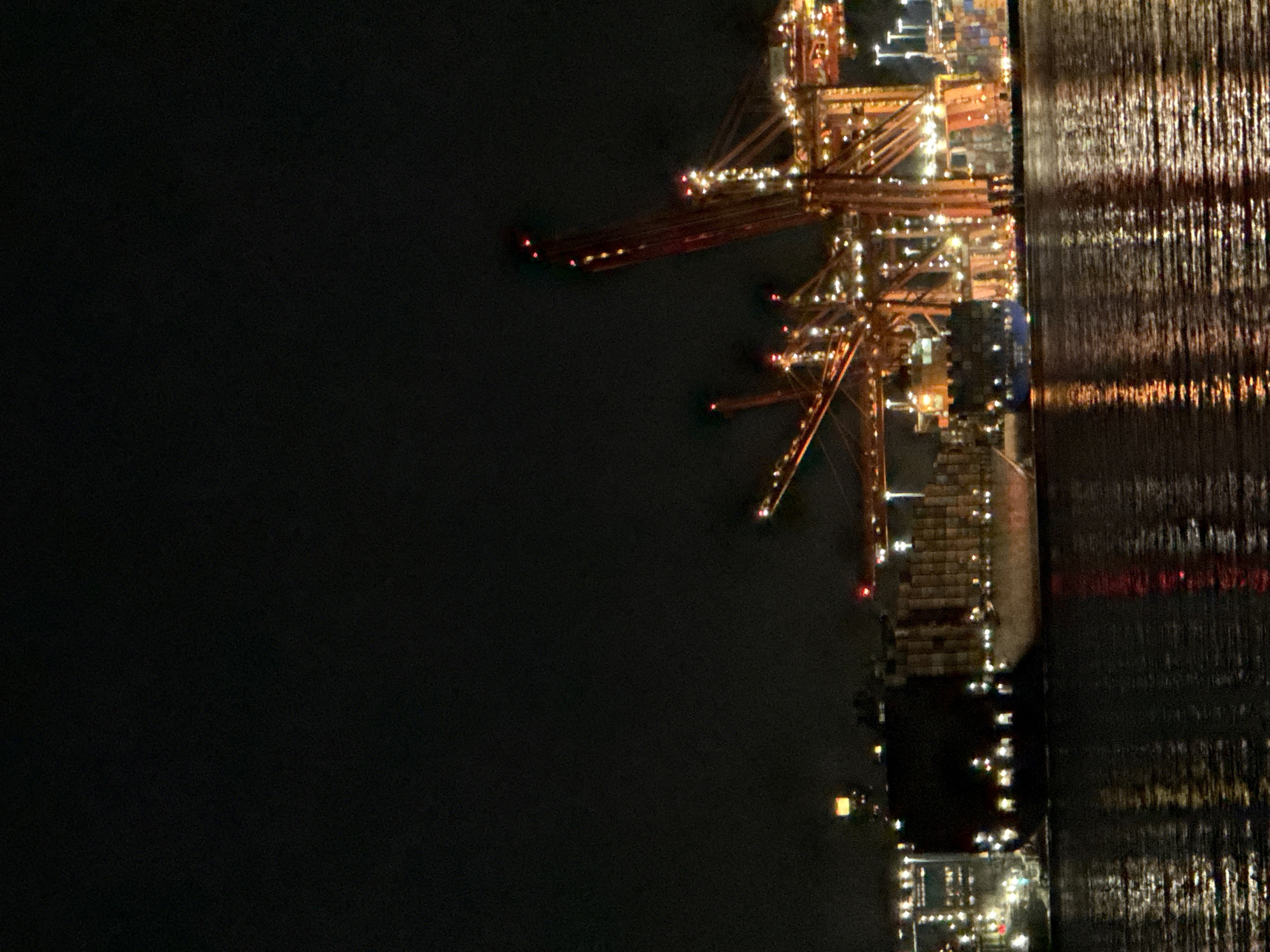 Container ship docked at Vancouver port during nighttime operations