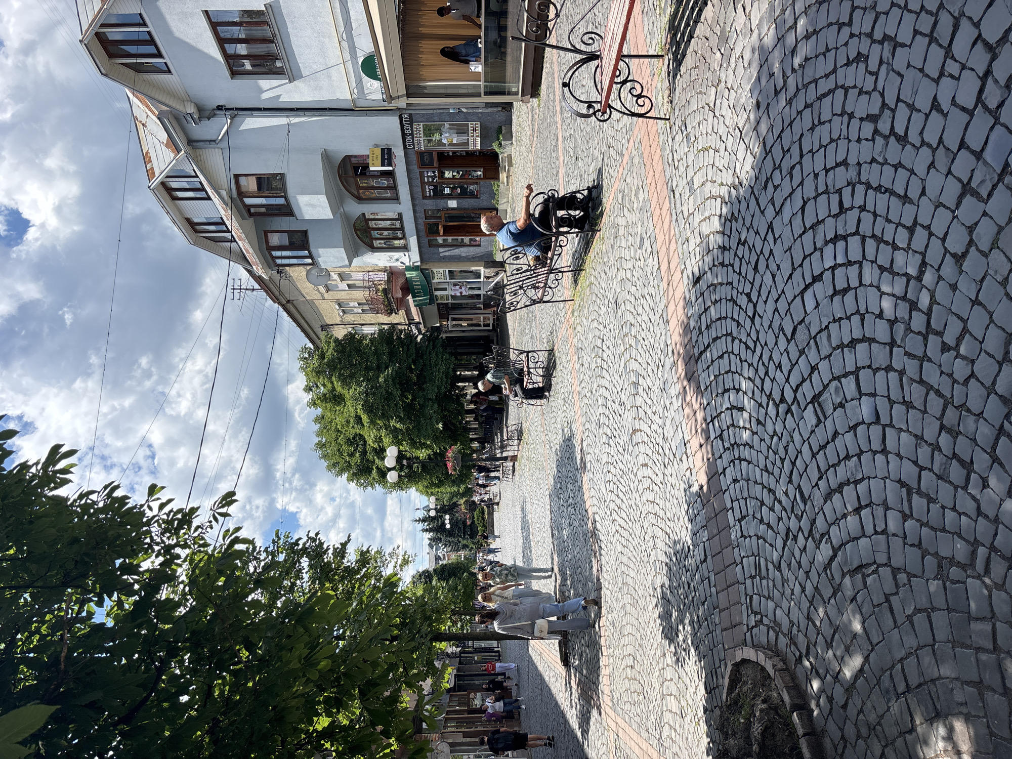 Cobblestone streets, flower beds, and local shops in a Ukrainian city