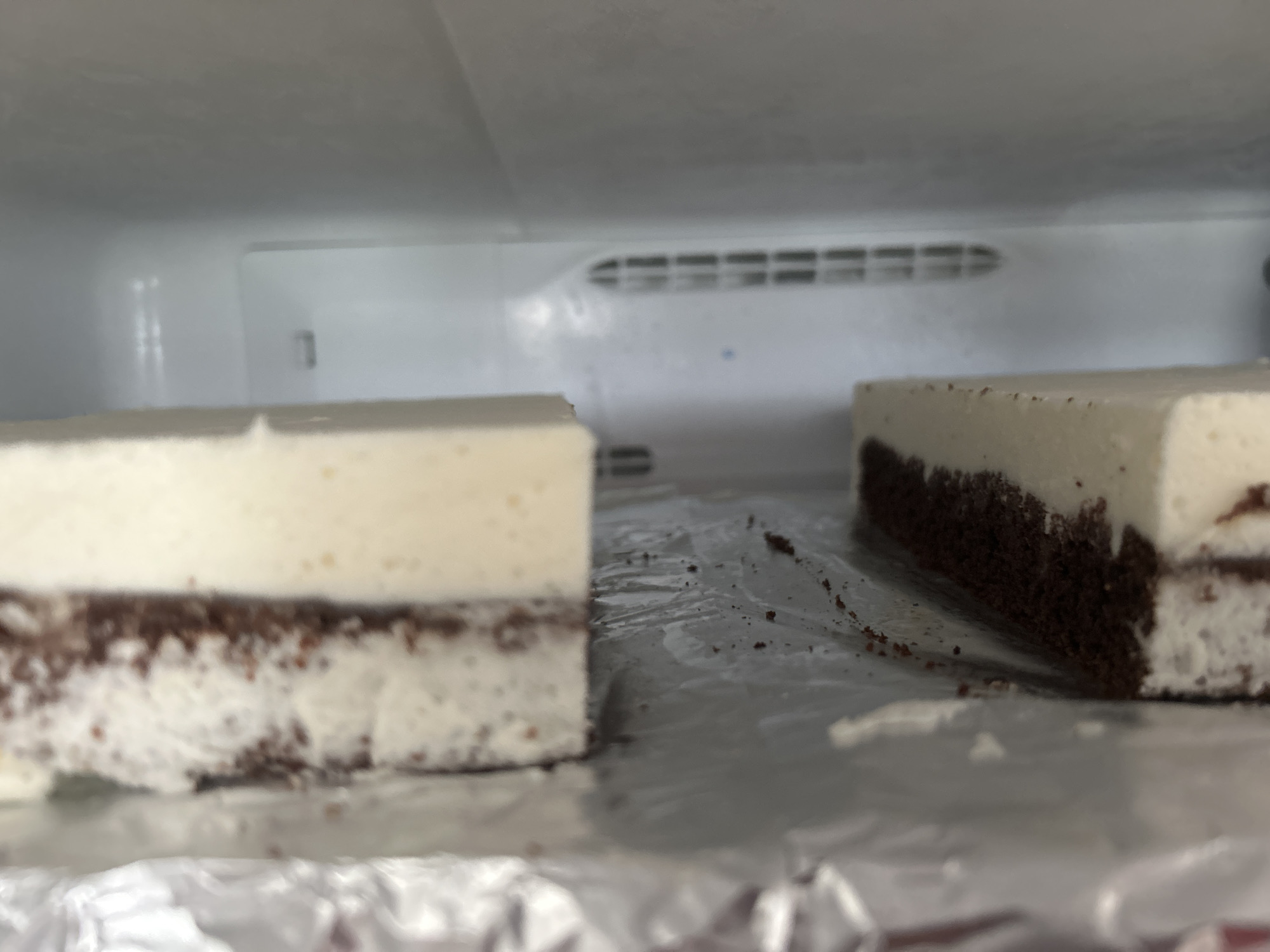 Layered dessert slices chilling on foil in a Richmond Hill fridge