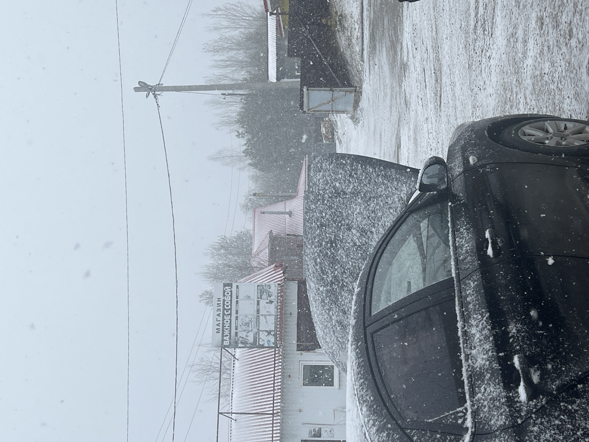 Snow-covered car parked on winter street in Kliuchi, Russia
