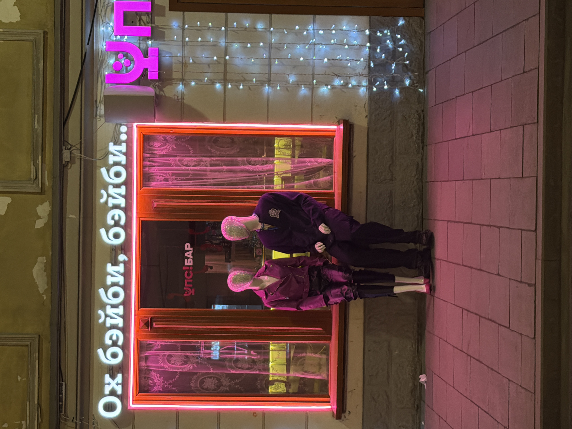 Moscow bar exterior with neon signage, mannequin display observed
