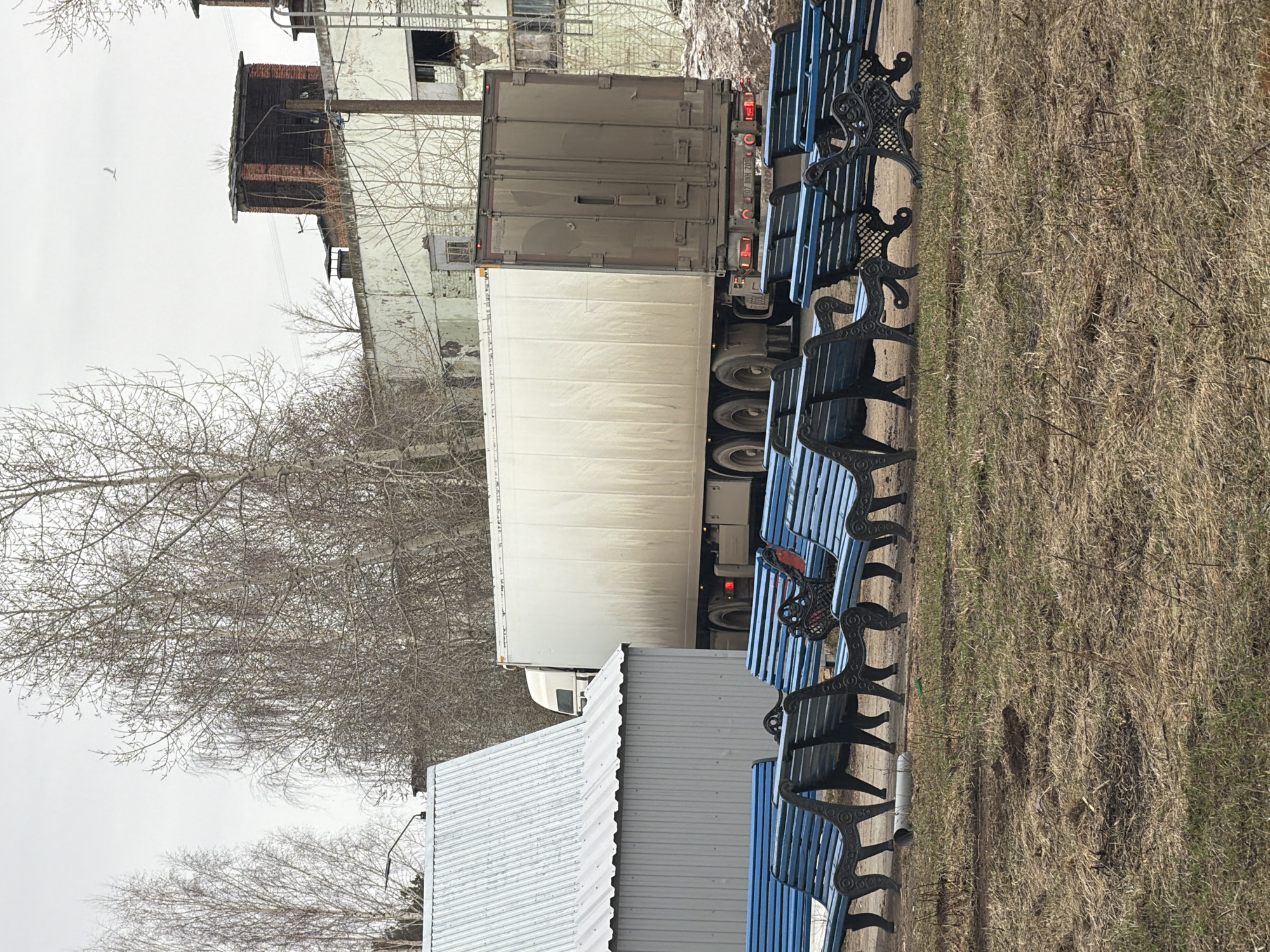 Blue park benches documented along roadside in Chaikovsky, Russia