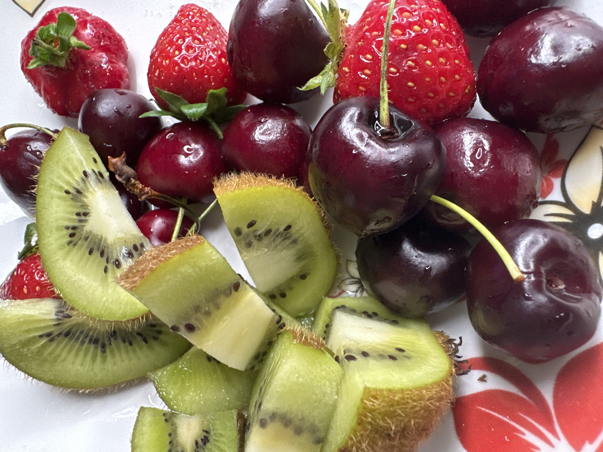 Mixed fruit plate shot from above, kiwi, cherries, and strawberries